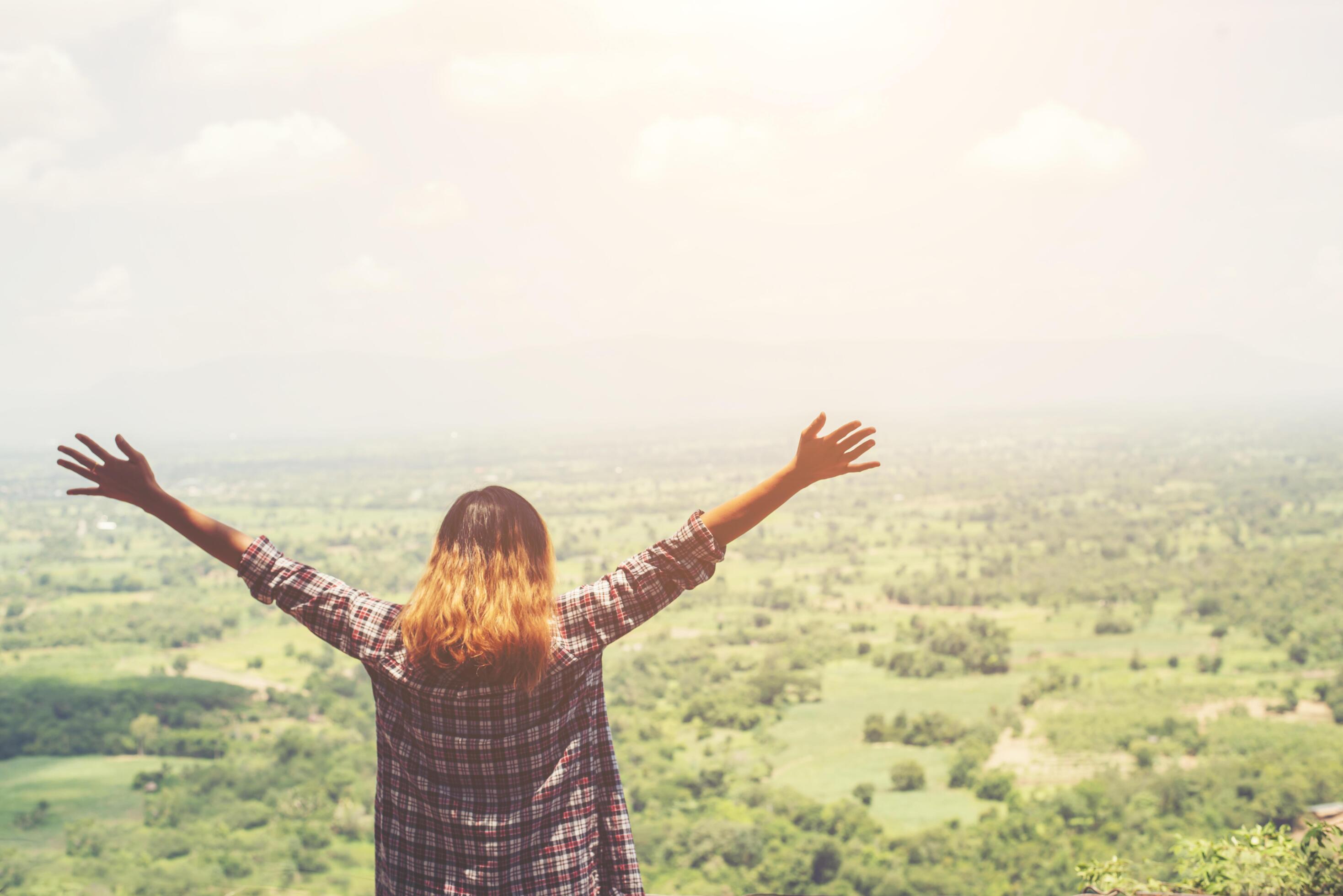 Young hipster woman standing alone outdoor with wild forest mountains on background Travel Lifestyle. Stock Free