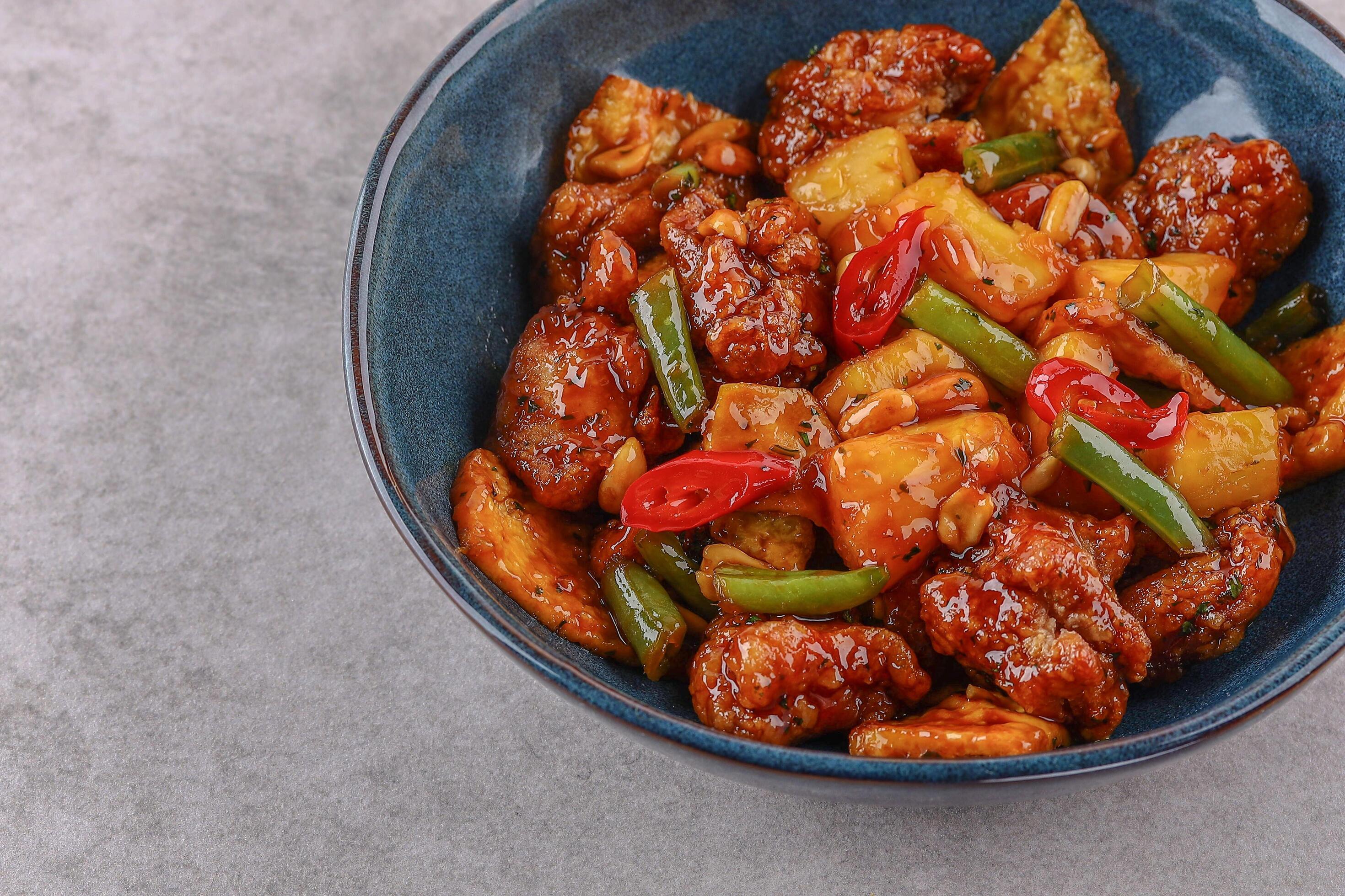 Chicken with pineapple in teriyaki sauce on a stone background studio shooting 1 Stock Free