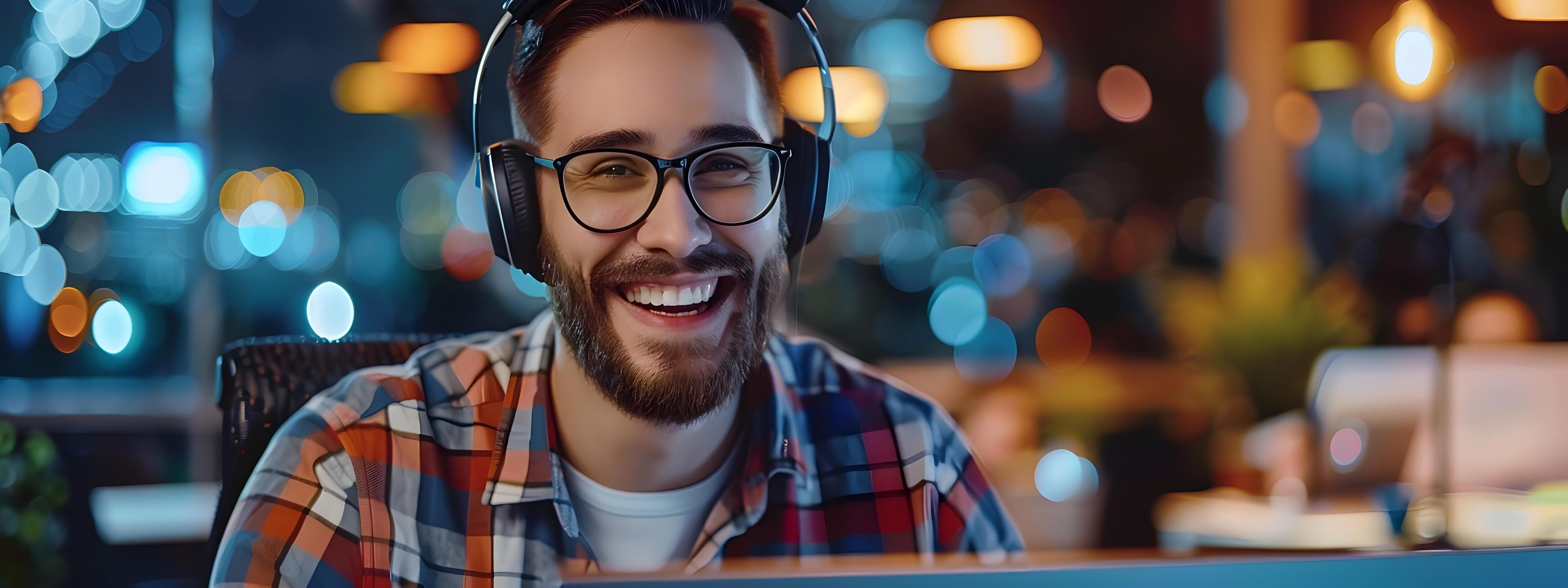 Smiling Young Technical Support Specialist Assisting Customers with Headphones and Computer in Modern Office Environment Stock Free