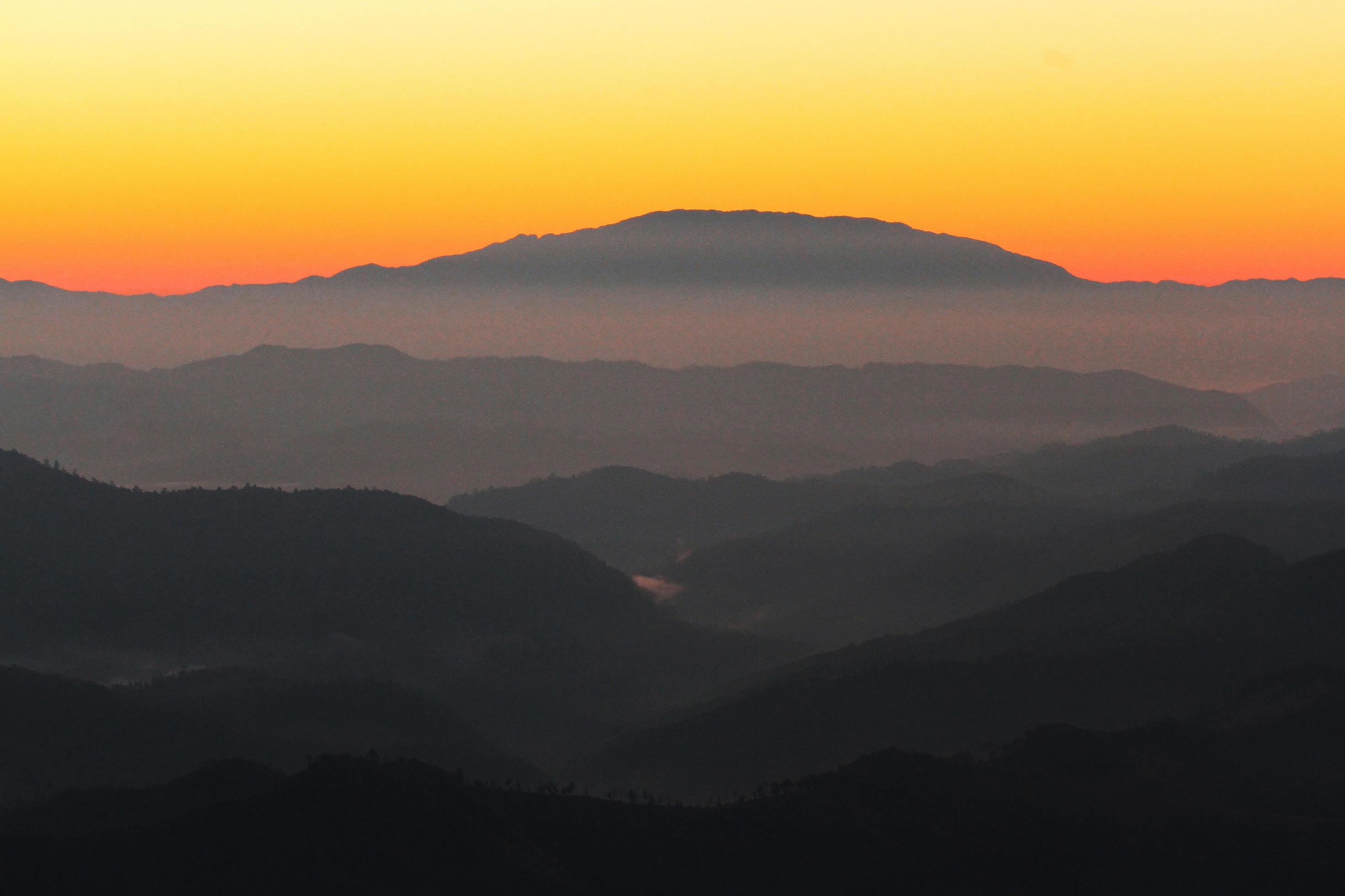 Sunset in sky and cloud, beautiful colorful twilight time with silhouette of mountain. Stock Free