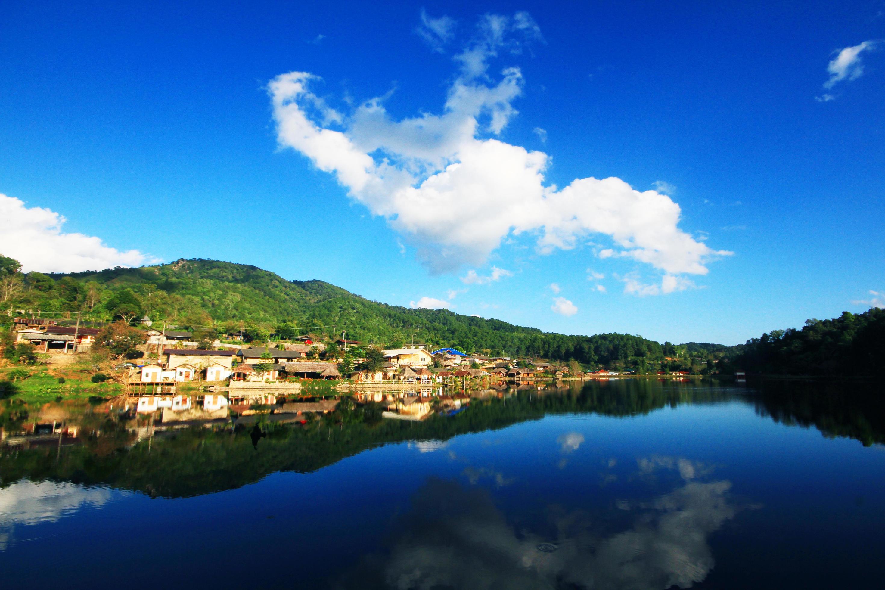 Beautiful landscape village on mountain and blue sky reflection in lake and river at Meahongson province, Thailand Stock Free