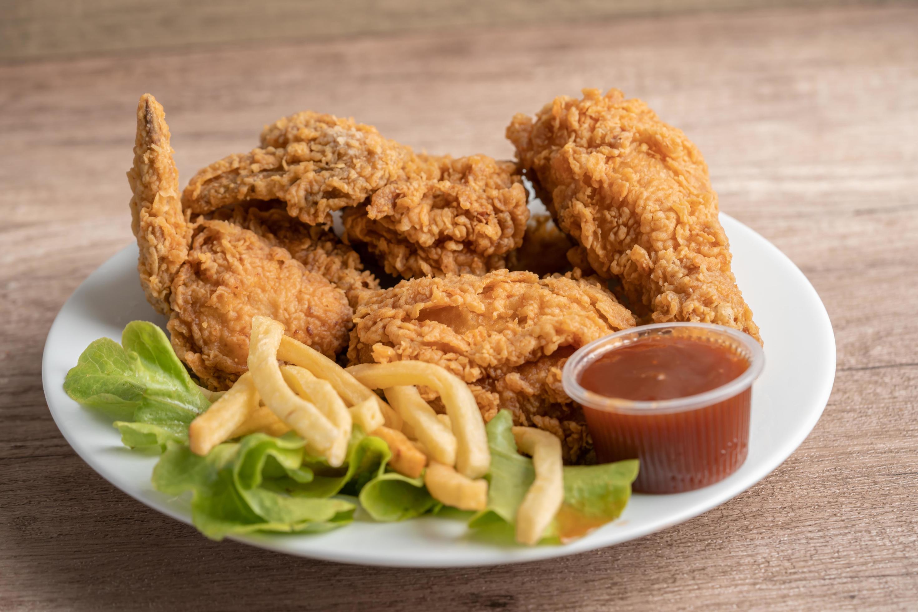 Fried chicken and potato chip with rosemary leaf, Junk food high calorie served on white plate Stock Free