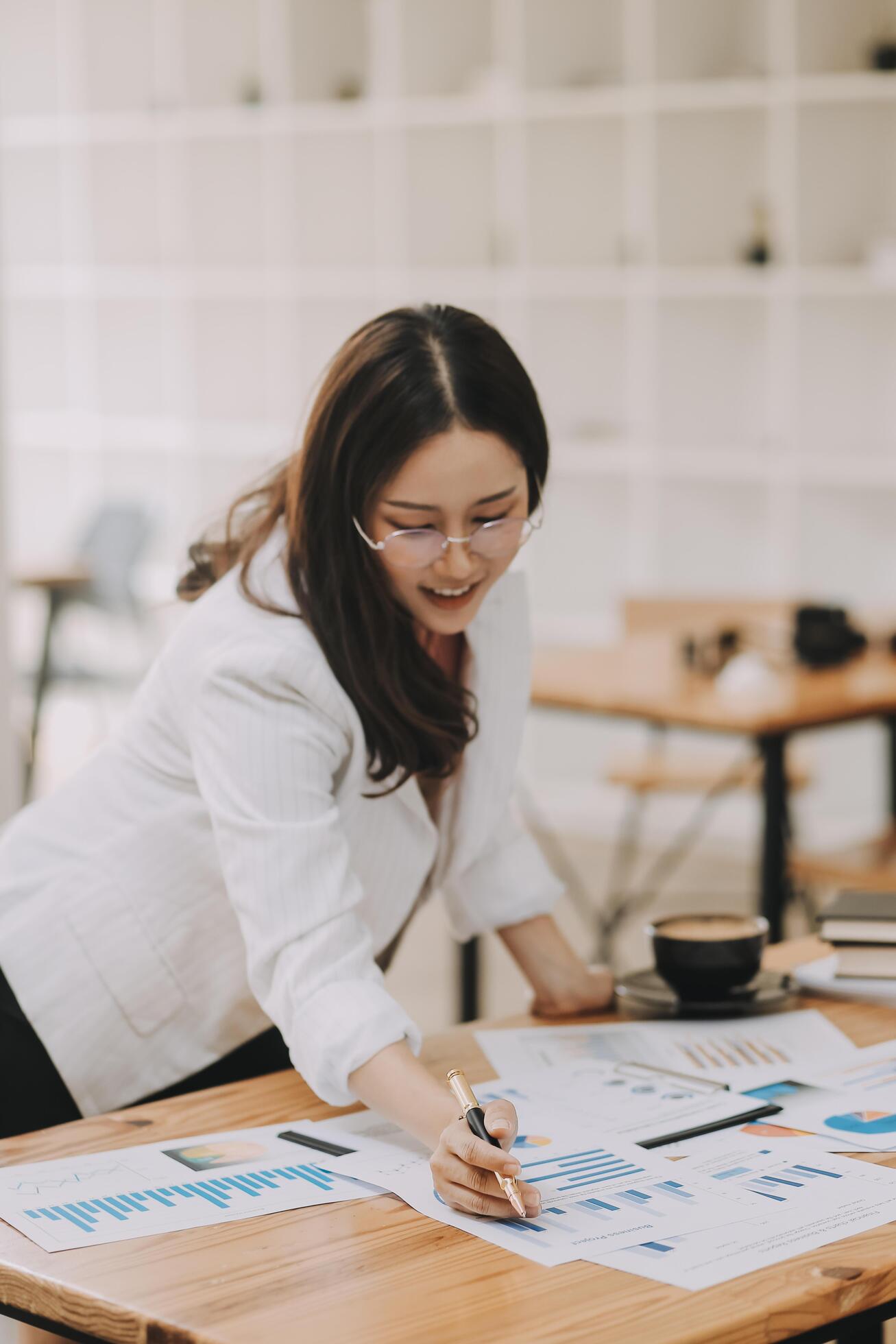 Happy young asian businesswoman sitting on her workplace in the office. Young woman working at laptop in the office. Stock Free