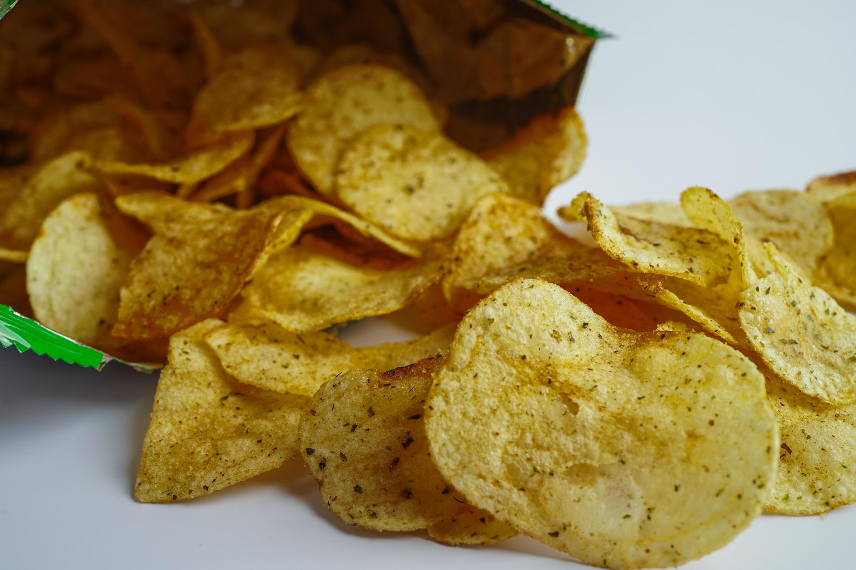 Potato chips in open bag, delicious BBQ seasoning spicy for crips, thin slice deep fried snack fast food in open bag. Stock Free