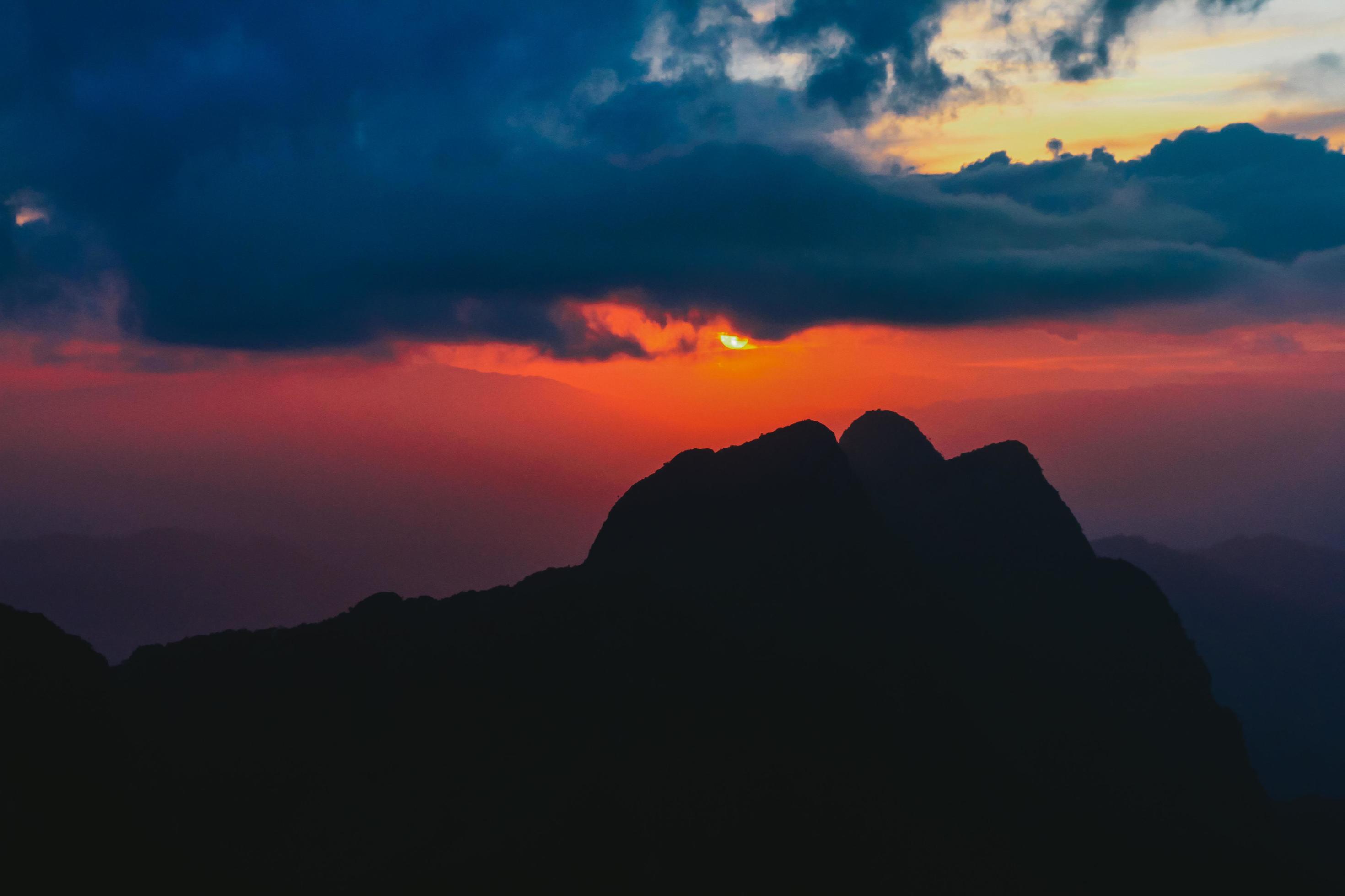 Sunset in sky and cloud, beautiful colorful twilight time with silhouette of mountain. Stock Free