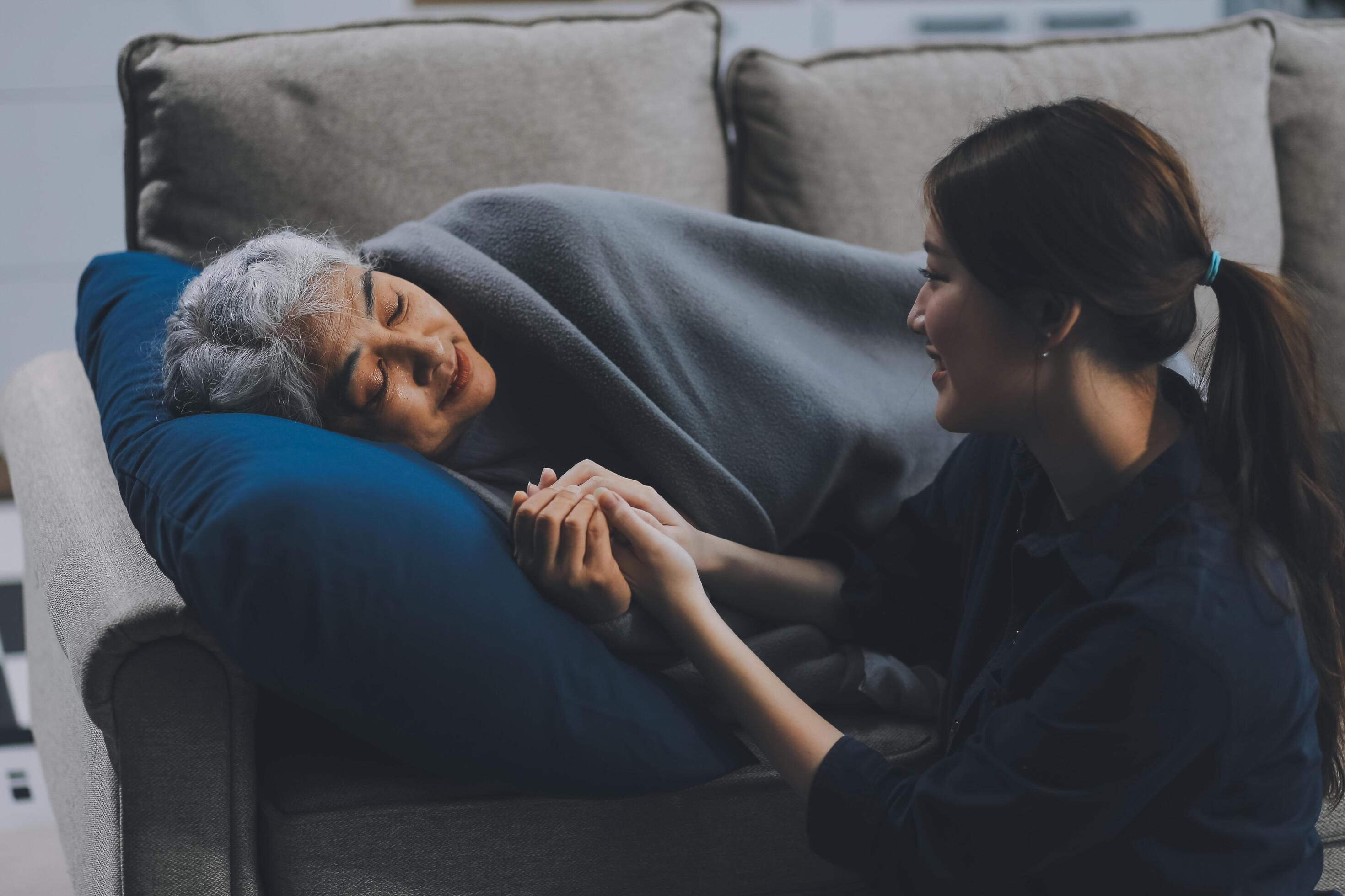 happy family Granddaughter takes care of her grandmother with warm cloths sitting on the sofa. Stock Free