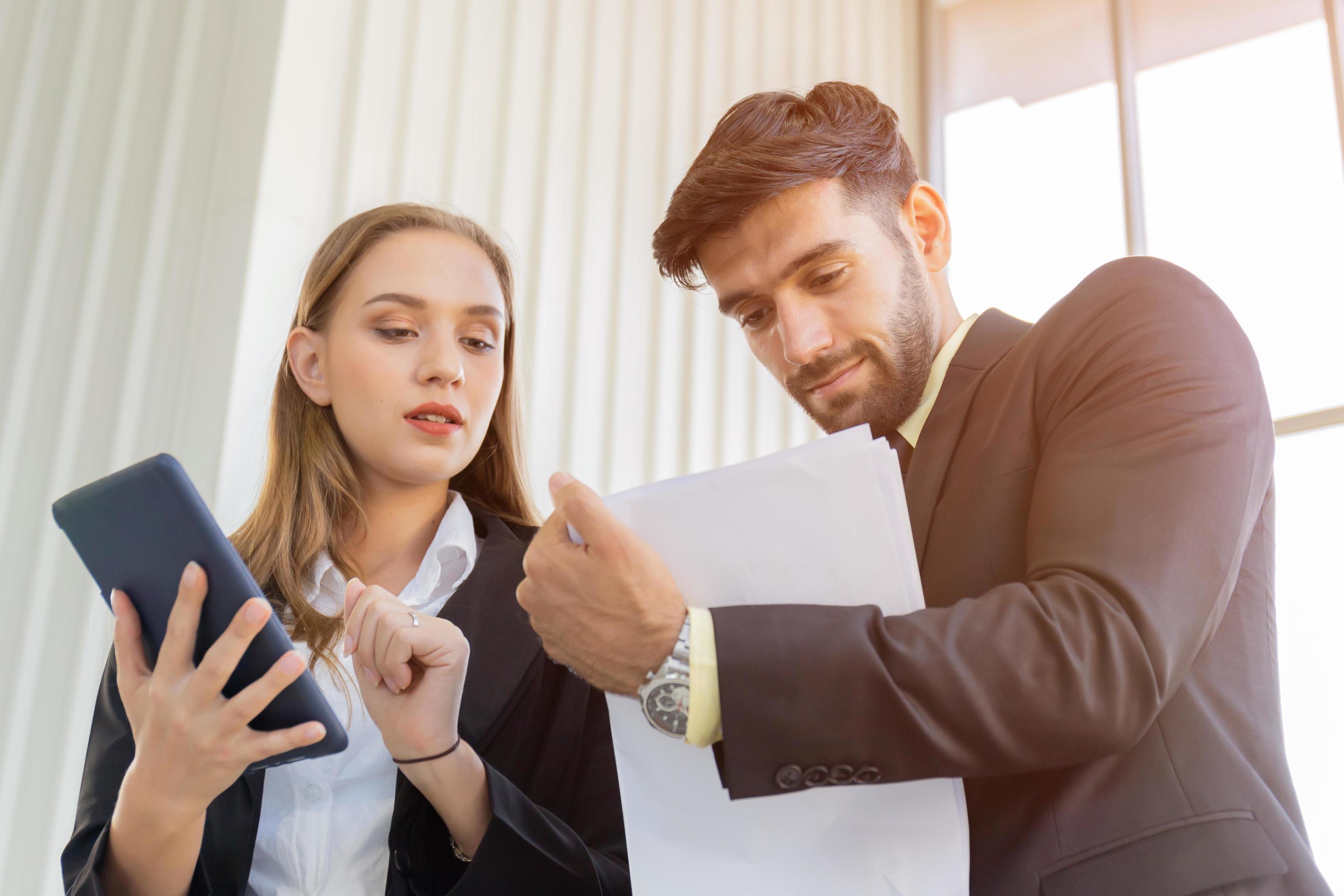 Two business men and women standing meeting in the office Stock Free