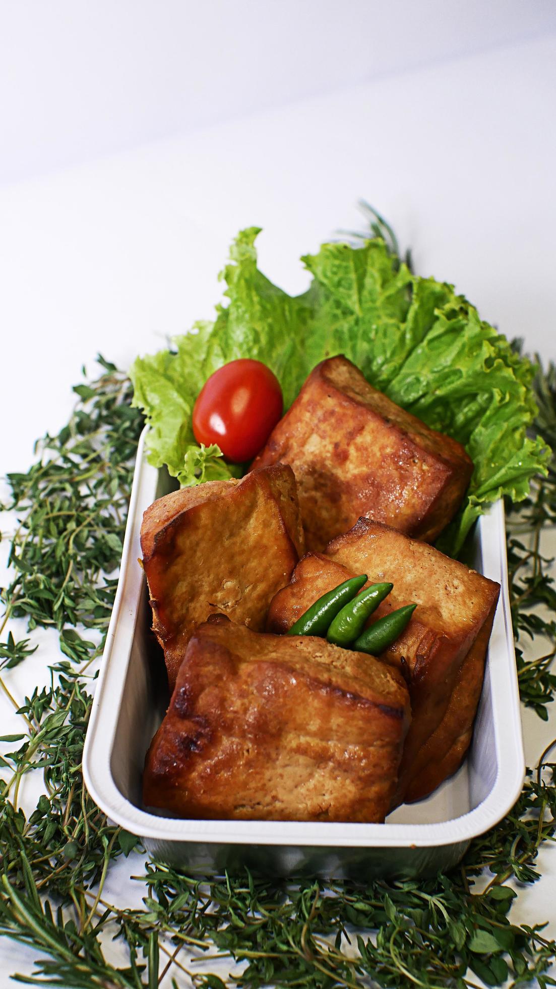 Fried tofu, small tomatoes and green chilies along with lettuce in one aluminum container, Indonesian street food on a white background Stock Free