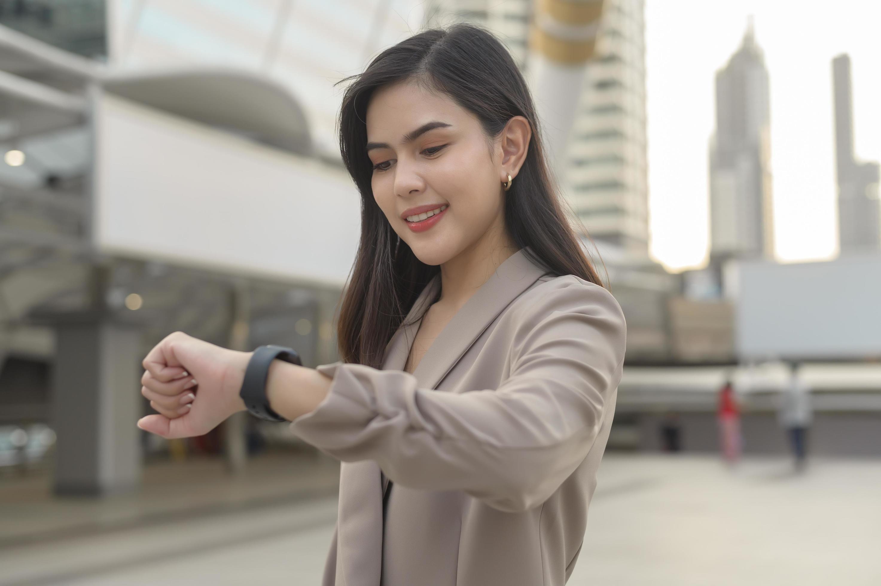 Businesswoman is using Smart watch in Modern city , business technology , city lifestyle concept Stock Free