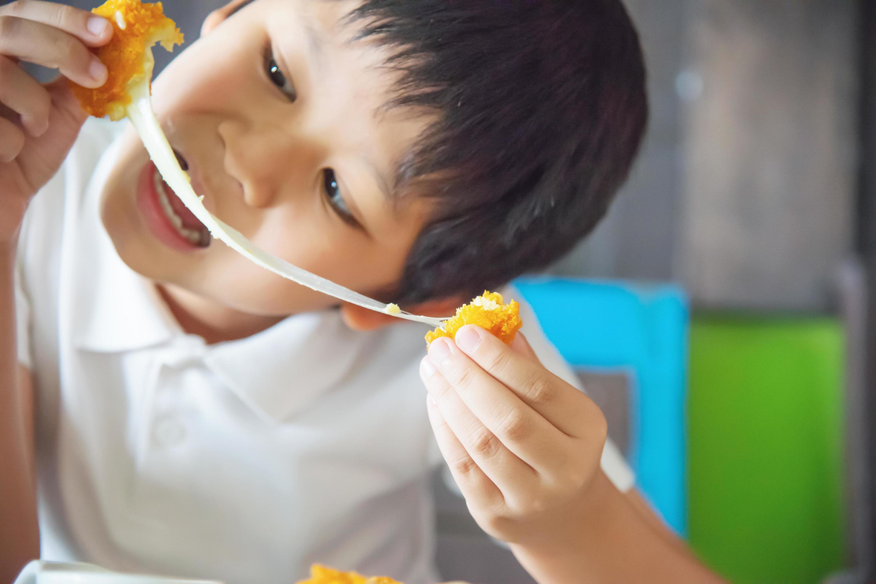 Boy ready to eat sticky stretch fried cheese ball – people and delicious cheese food concept Stock Free