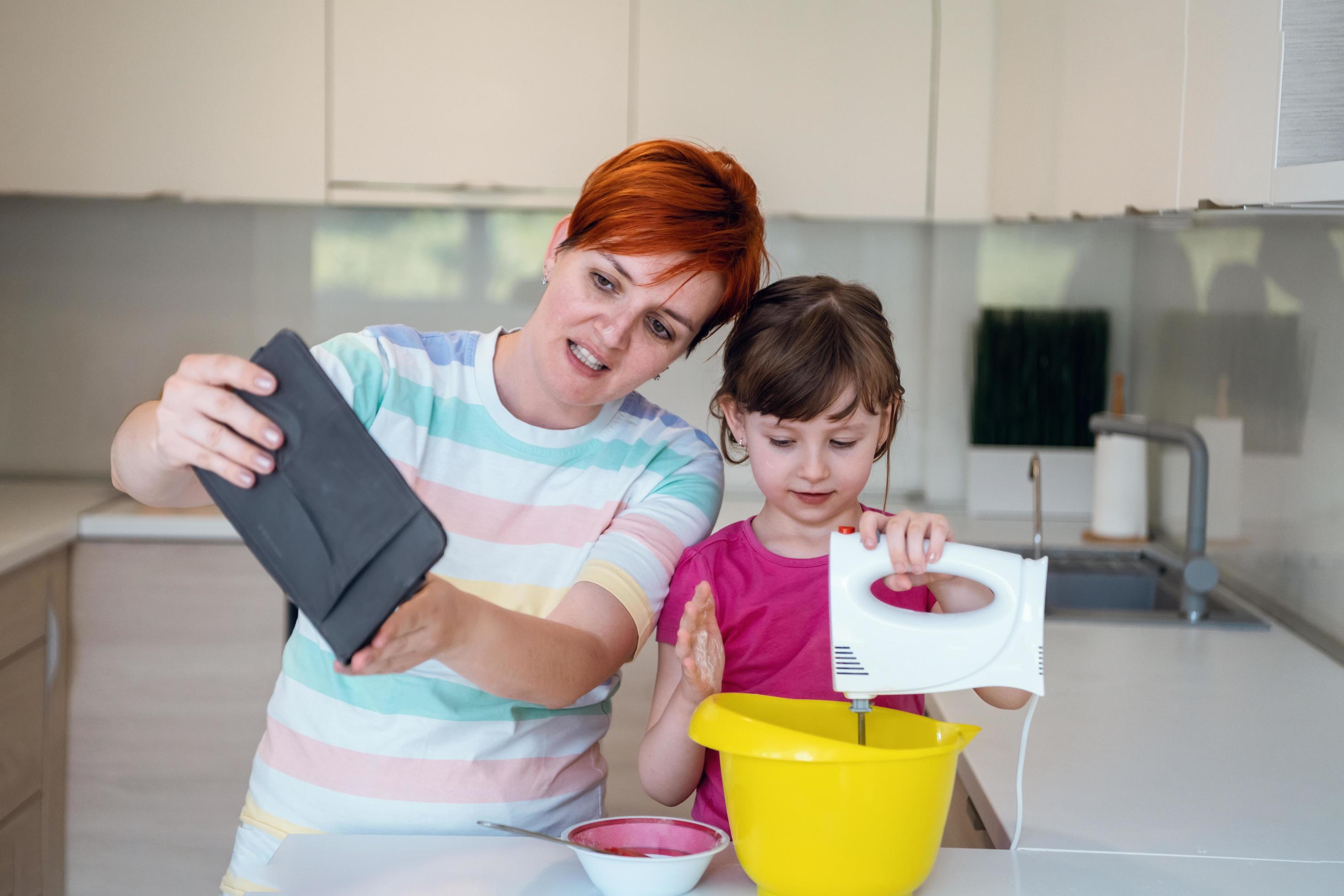 little girl and mom making tastz cake in kithen family having fun at home Stock Free