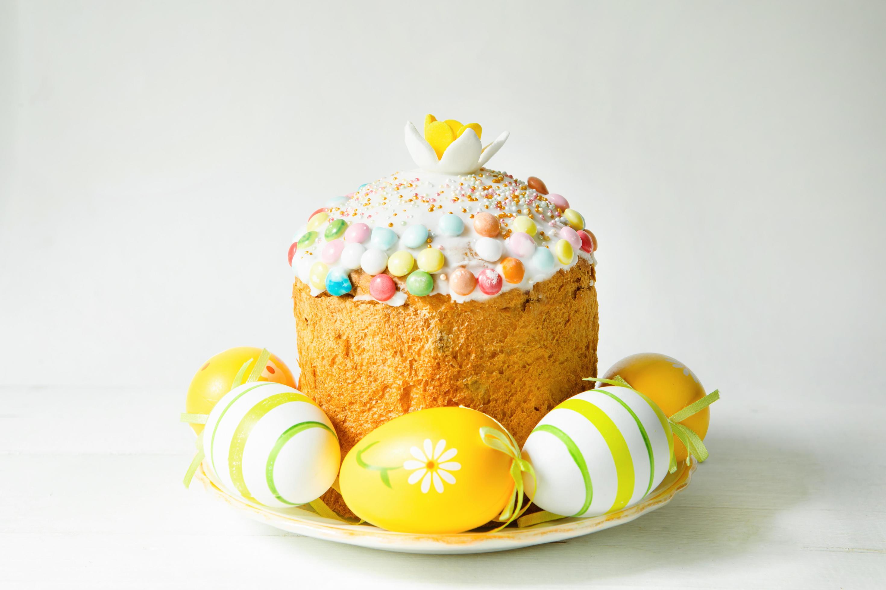 Easter cake with painted eggs on a platter in a gray interior. Traditional festive food Stock Free