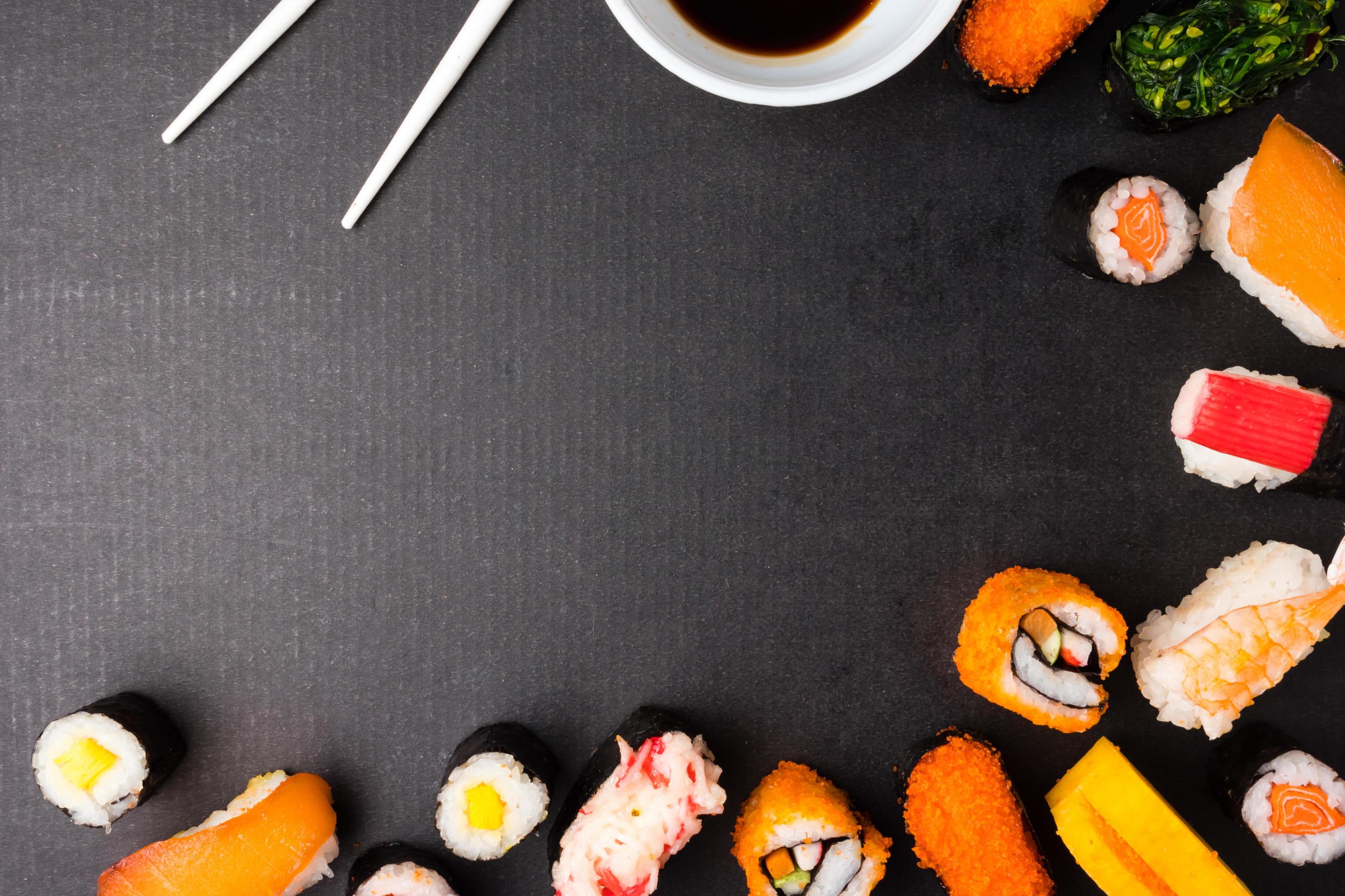 Top view of Sushi set with chopsticks and sauce on black background, Japanese food. Free space for text Stock Free