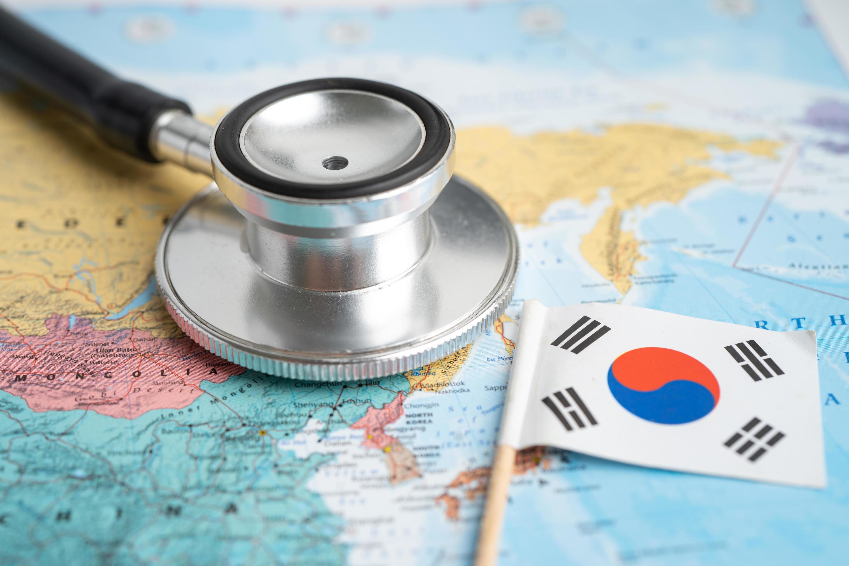 Bangkok, Thailand – February 1, 2022 Black stethoscope with Korea flag on world map background, Business and finance concept. Stock Free