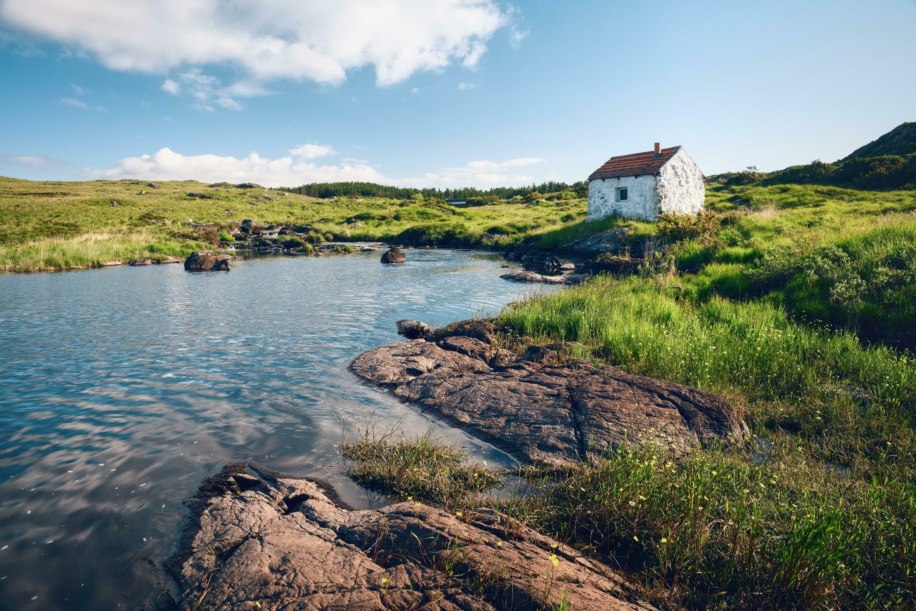 Beautiful landscape scenery with cottage by the river on green meadow at Connemara National park in County Galway, Ireland Stock Free