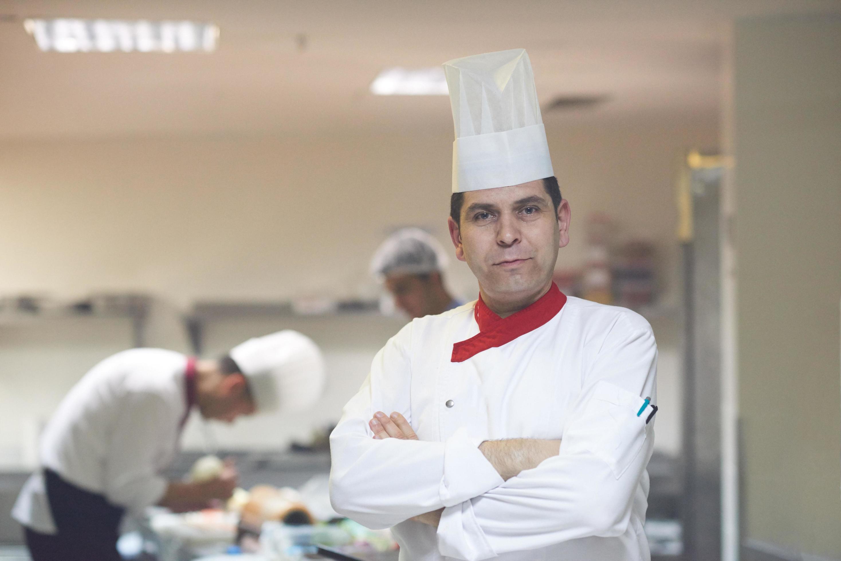 chef in hotel kitchen preparing and decorating food Stock Free