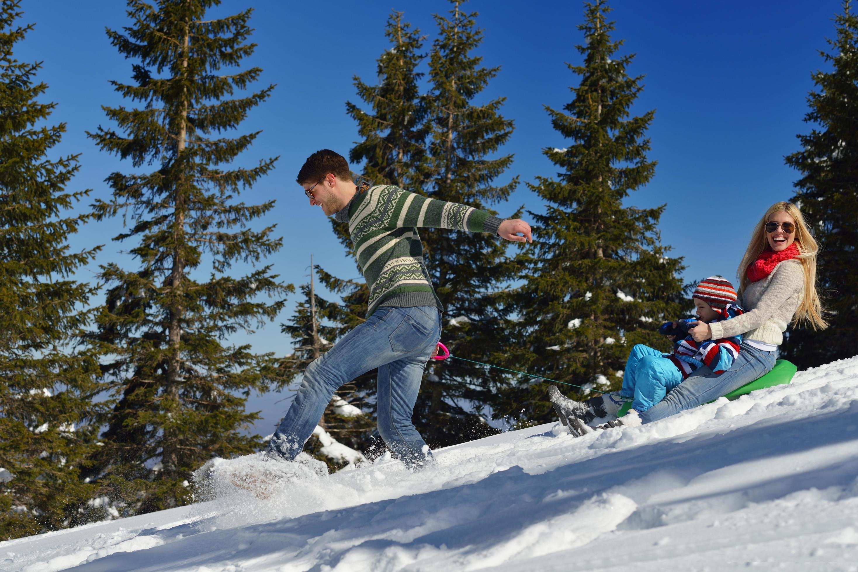 family having fun on fresh snow at winter vacation Stock Free