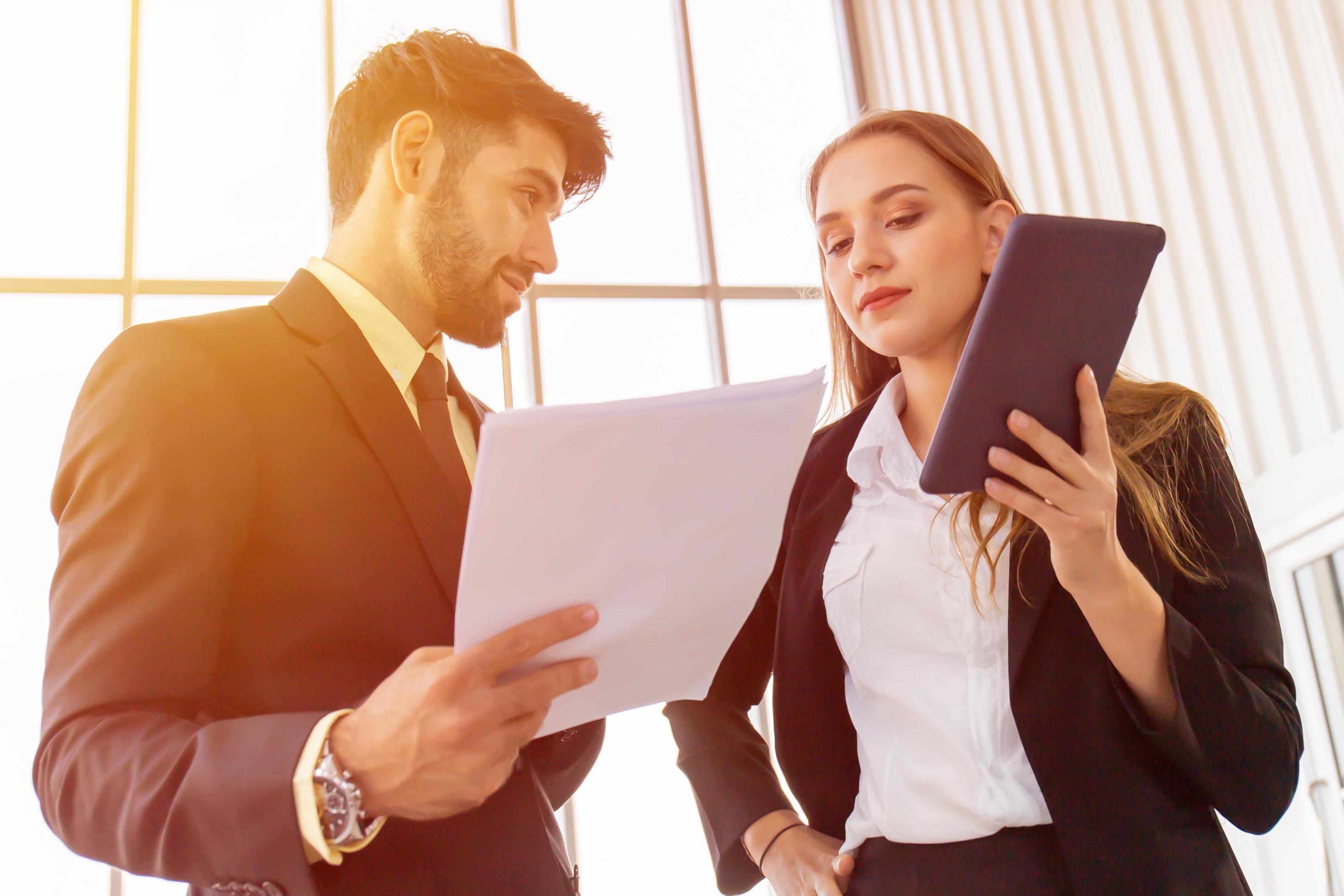 Two business men and women standing meeting in the office Stock Free