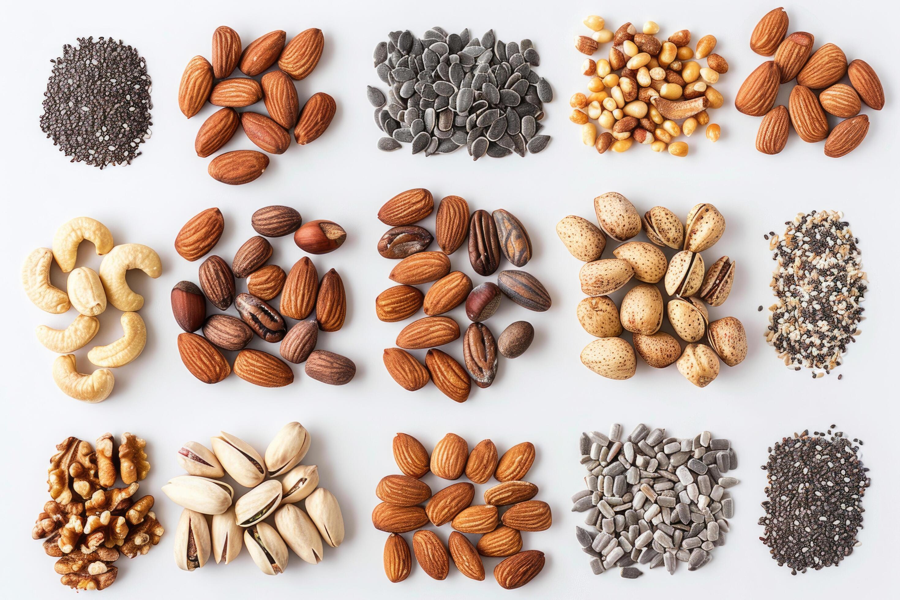 An assortment of nuts and seeds spread out on a white background Stock Free