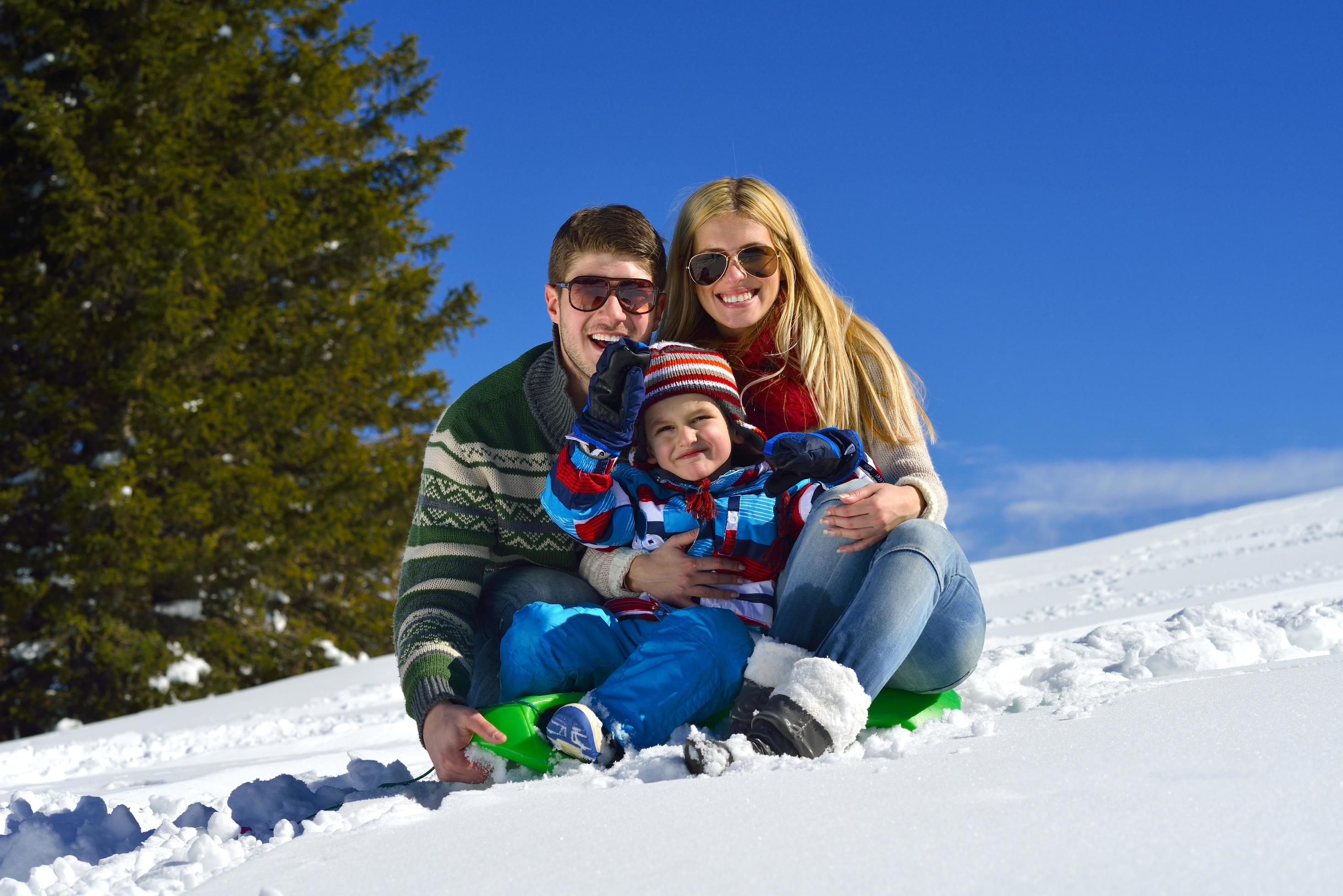 family having fun on fresh snow at winter vacation Stock Free