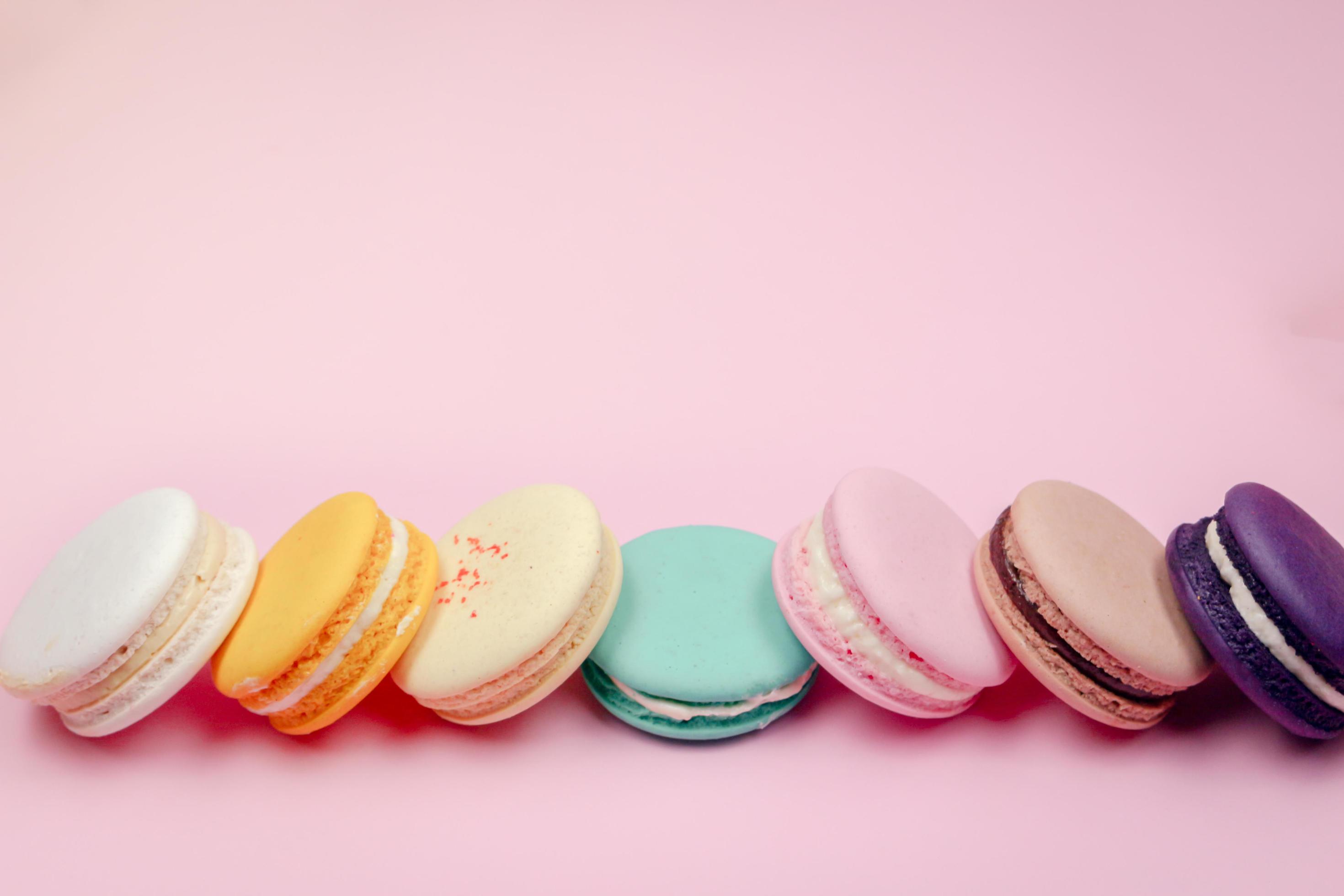 Colorful french macarons macaroons cake, delicious sweet dessert on a pink background with copyspace, food background concept. Stock Free