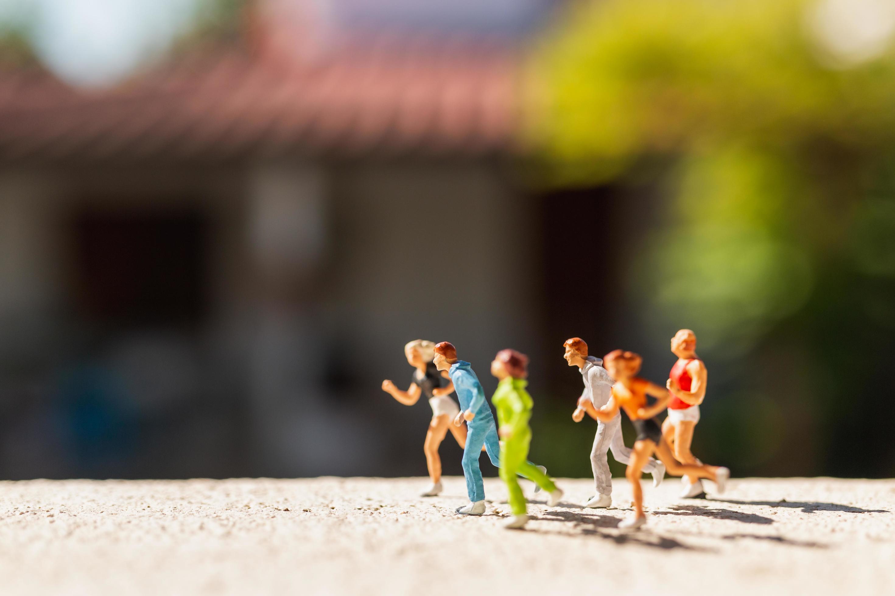 Miniature group of people running on a concrete road, healthy lifestyle concept Stock Free