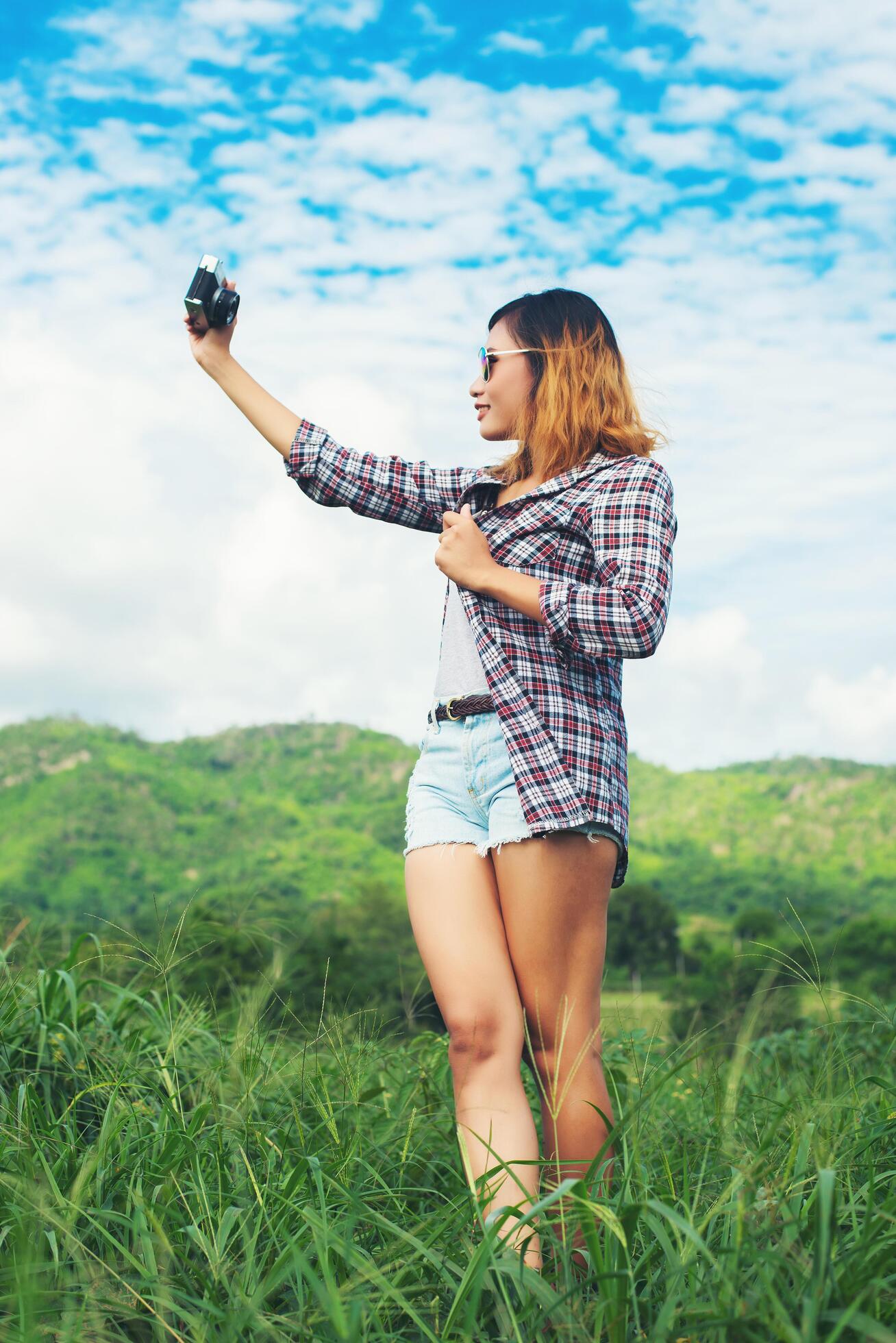 Young Hipster Woman with retro camera taking shot outdoor landscape ,Lifestyle mountain nature on background. Stock Free