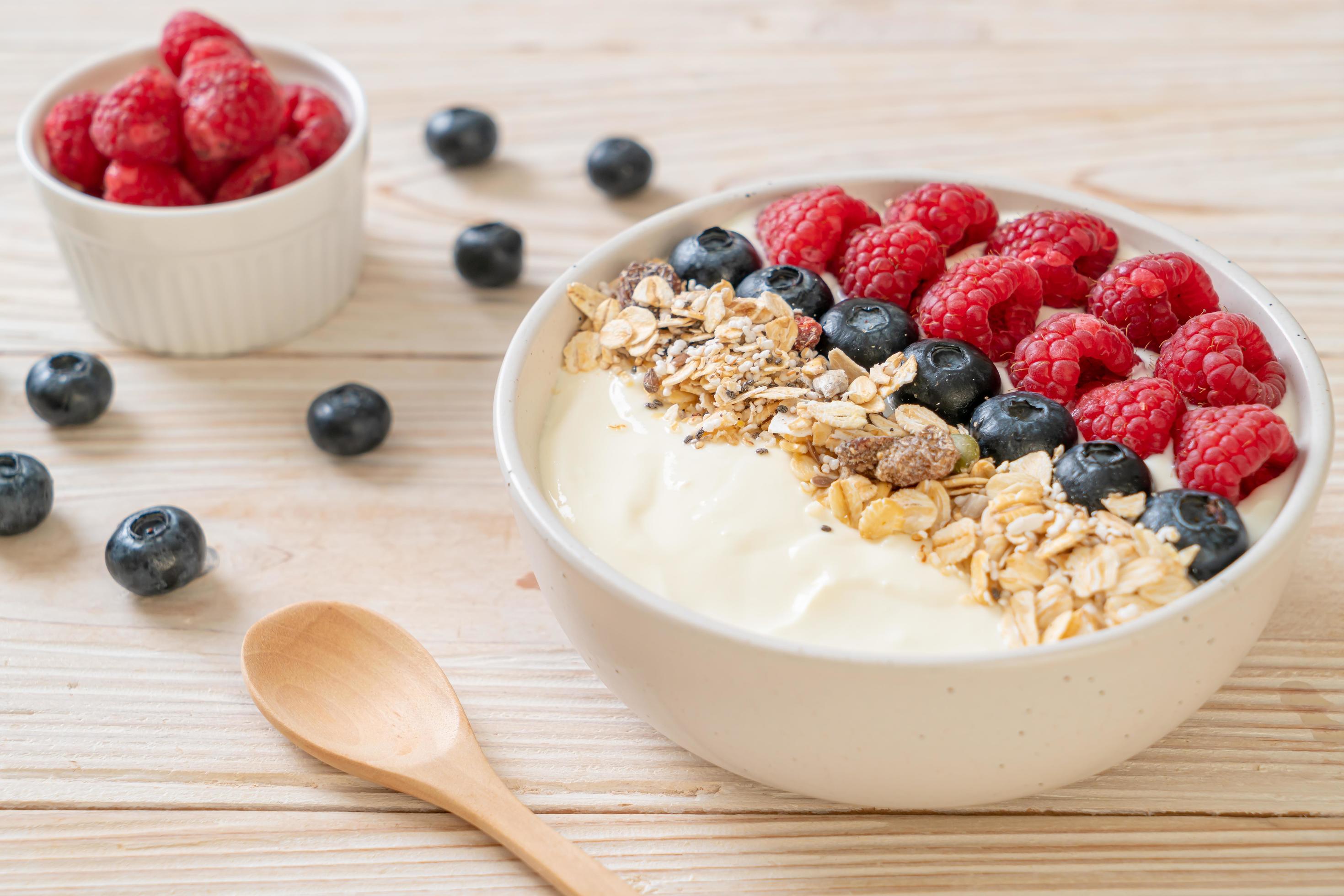 Homemade yogurt bowl with raspberry, blueberry and granola – healthy food style Stock Free