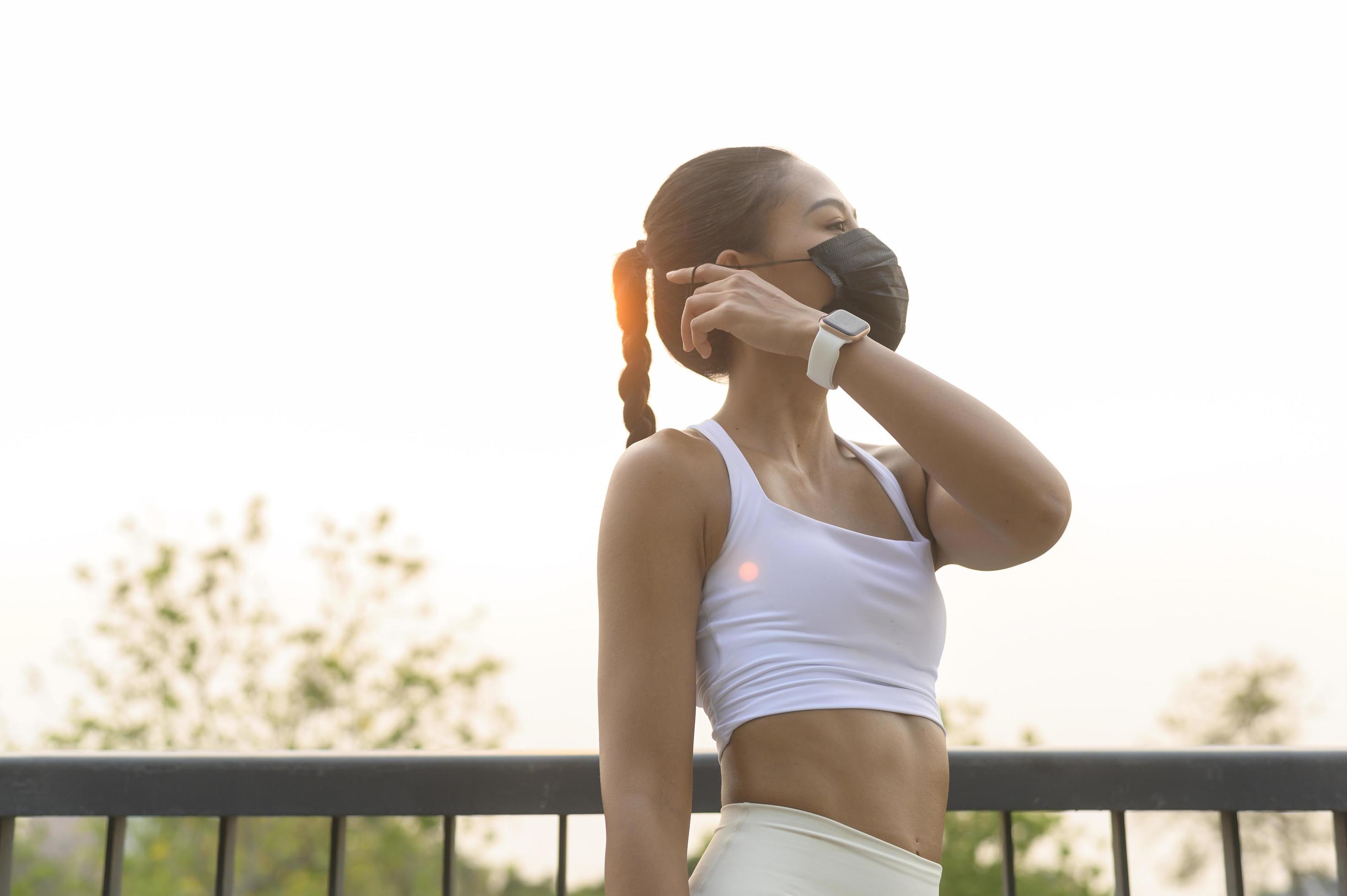 Young fitness woman in sportswear taking face mask off while exercise in city park, Health and Lifestyles. Stock Free