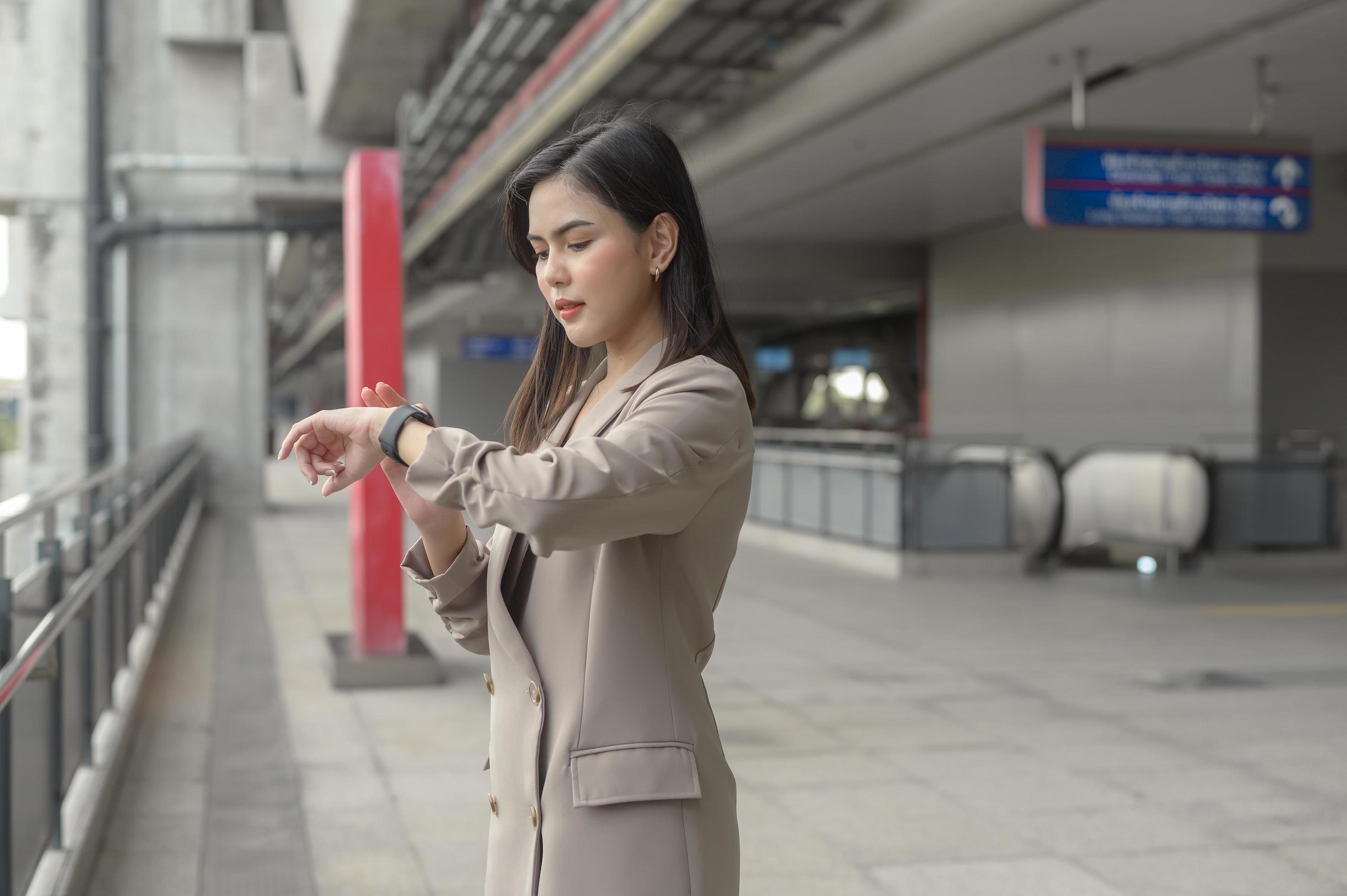 Businesswoman is using Smart watch in Modern city , business technology , city lifestyle concept Stock Free