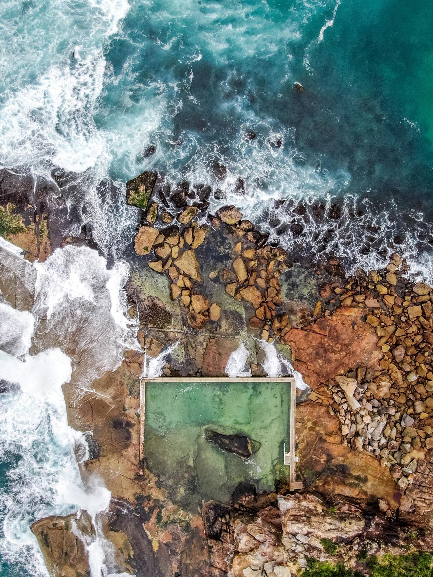 Aerial view of waves crashing on rocks Stock Free