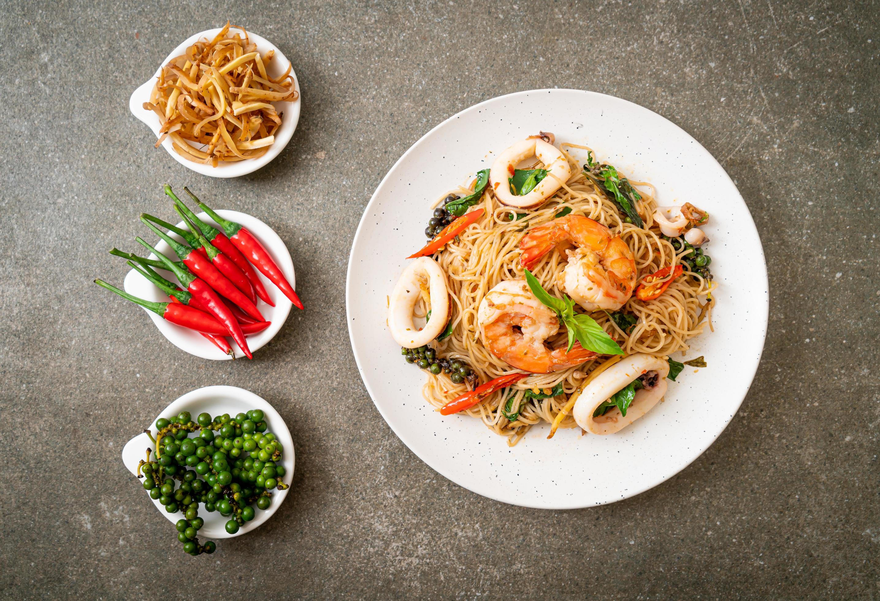 Stir-fried Chinese noodles with basil, chili, shrimp, and squid – Asian food style Stock Free