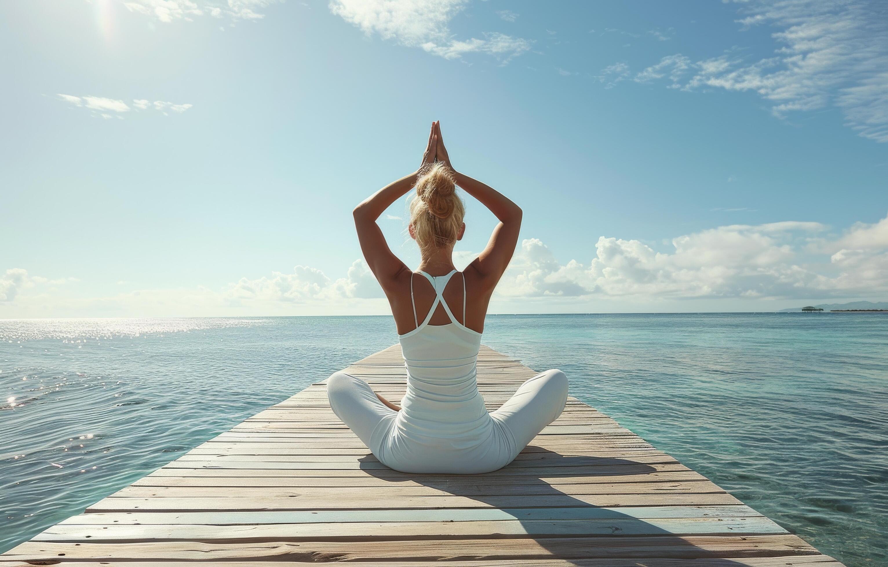 Woman Practicing Yoga on Wooden Dock During Sunrise at the Beach Stock Free