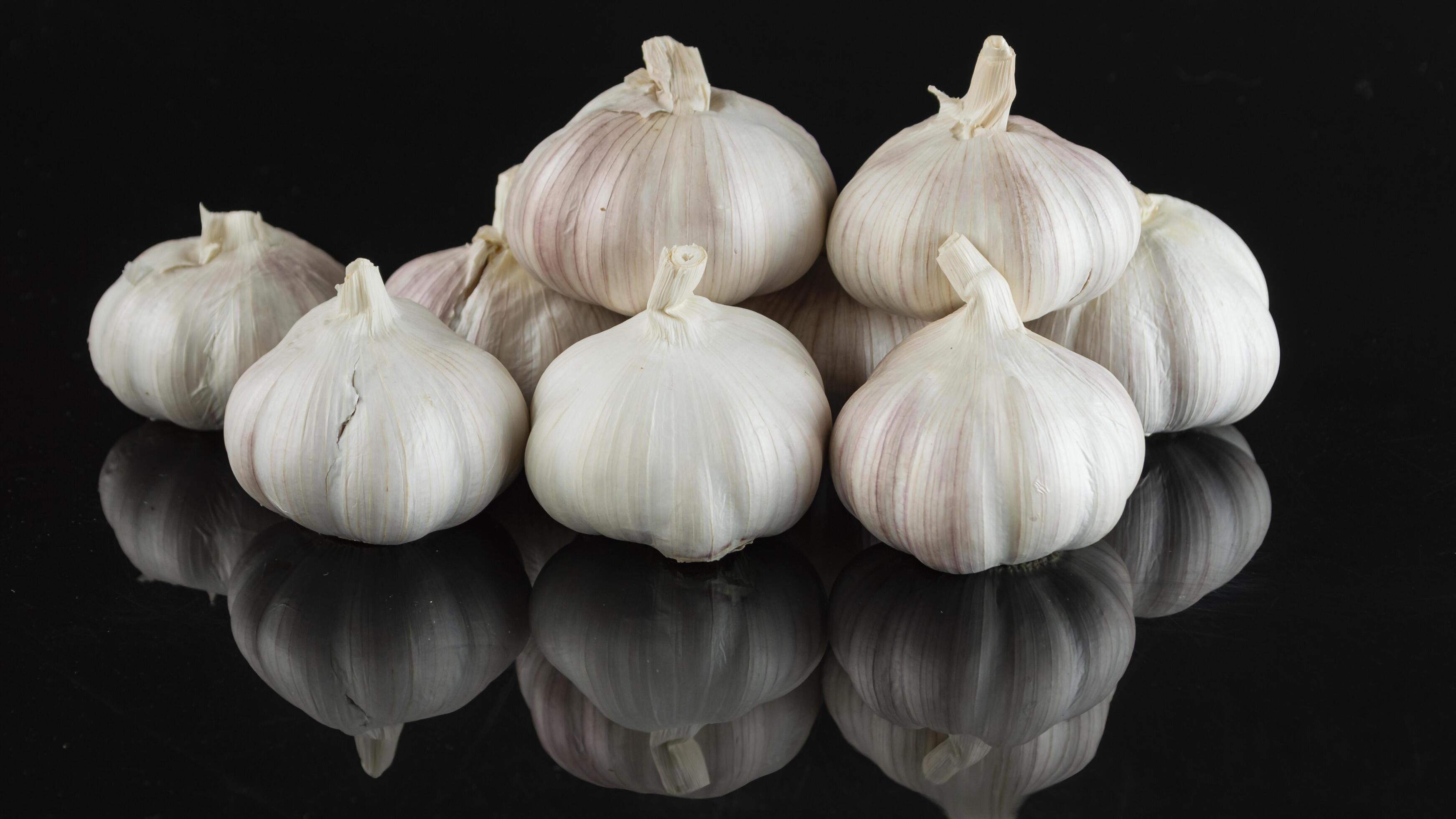 a group of garlic bulbs on a black background Stock Free