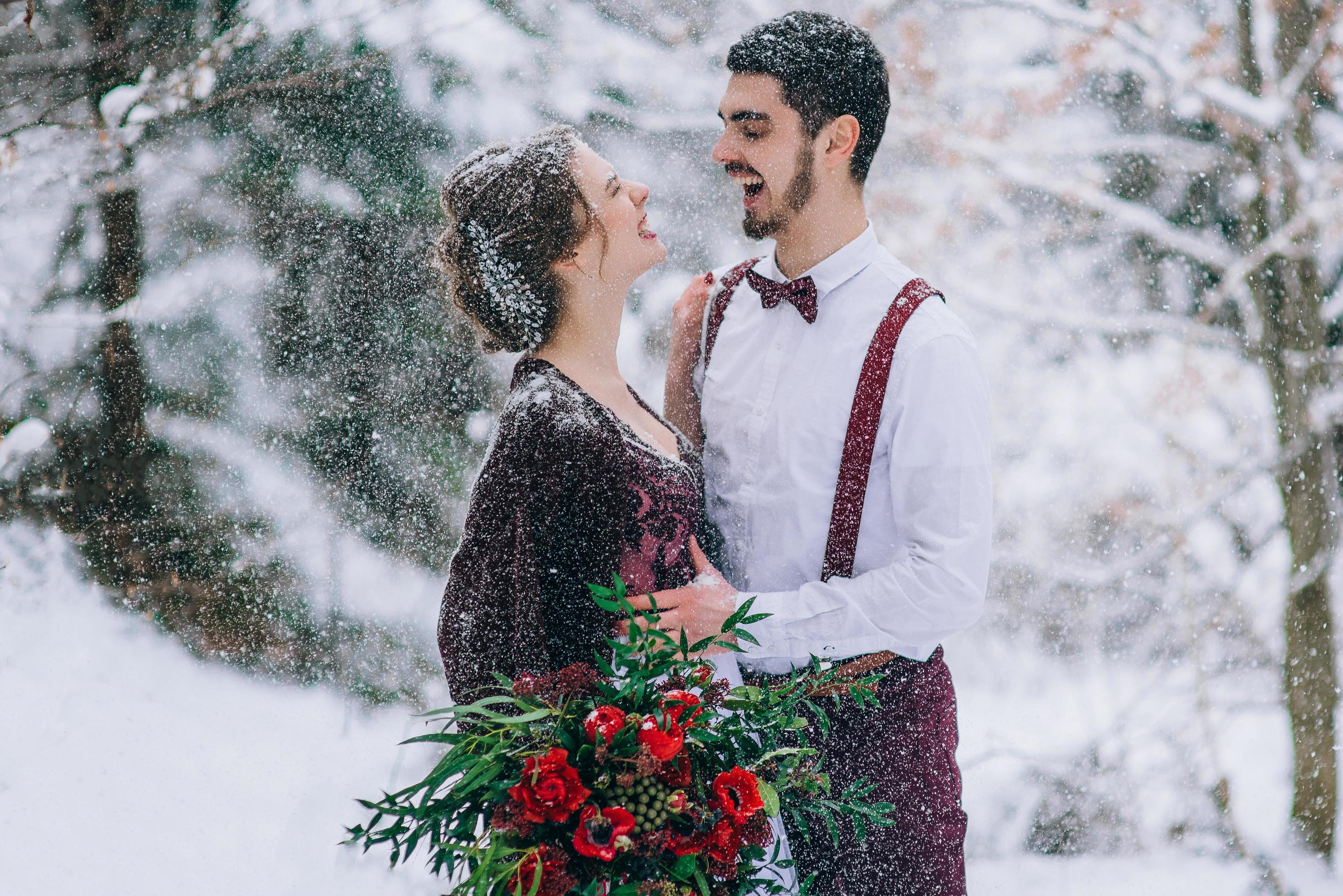 Groom in a brown and bride in burgundy in the mountains Stock Free