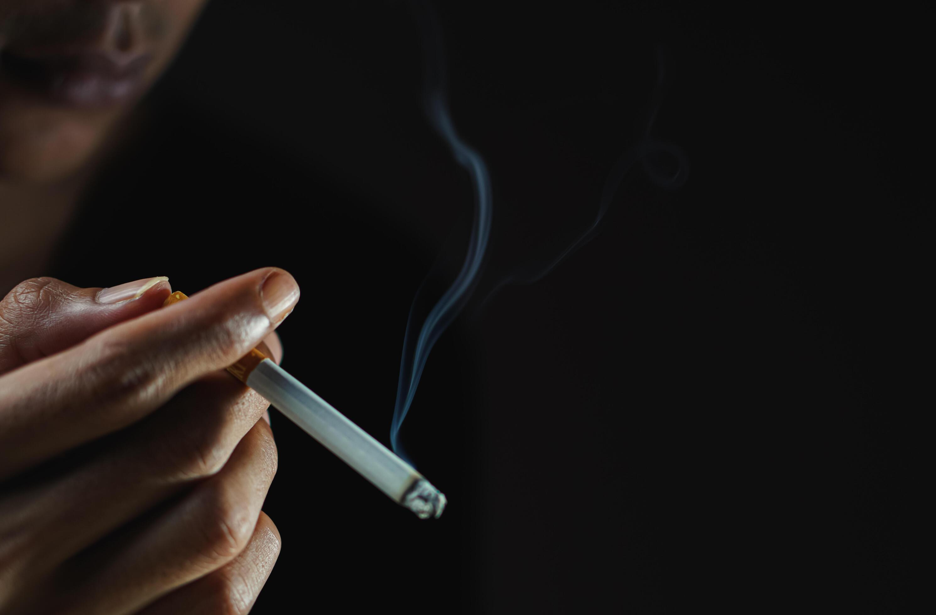 A man smoking cigarette in dark room Stock Free