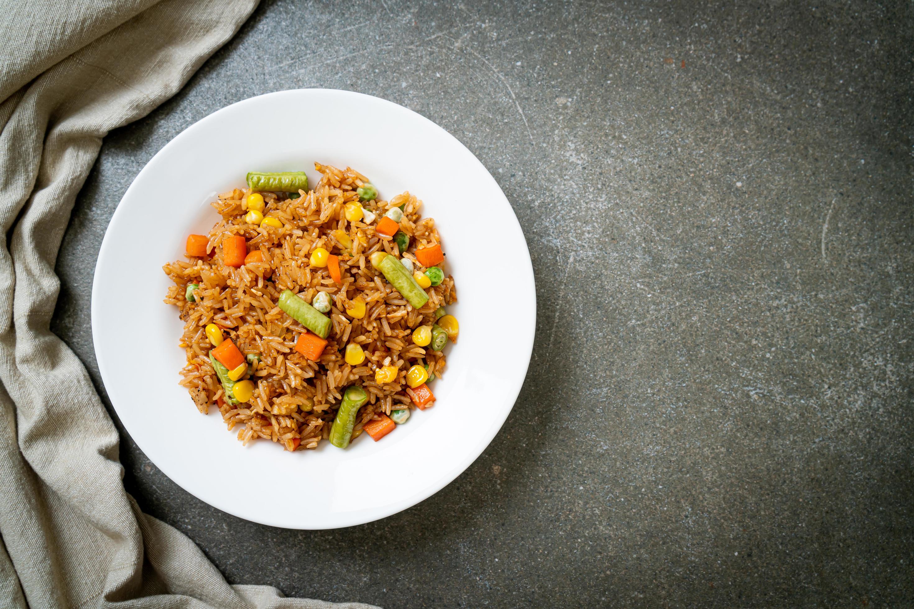 Fried rice with green peas, carrots, and corn – vegetarian and healthy food style Stock Free