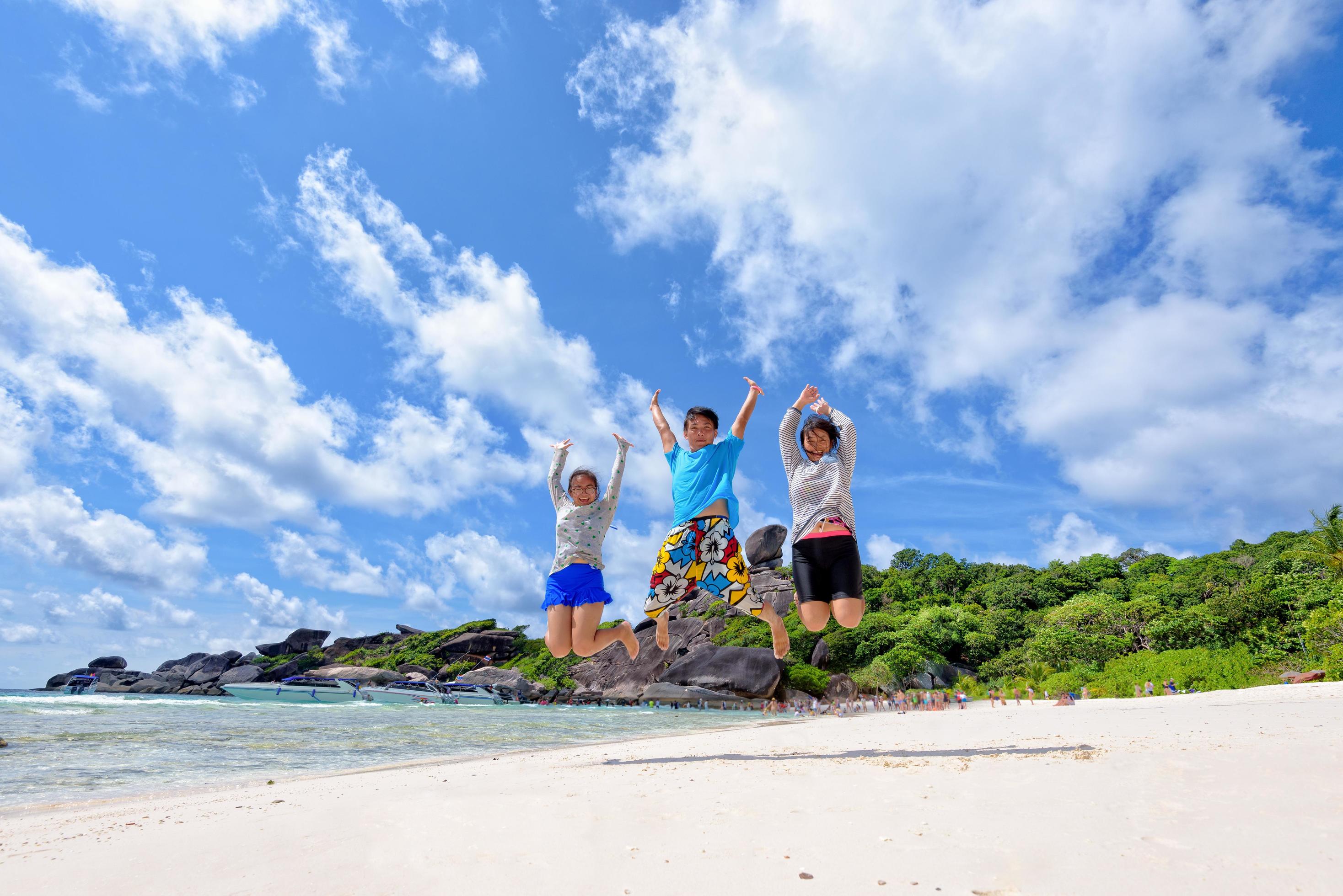 Happy family jumping on beach in Thailand Stock Free