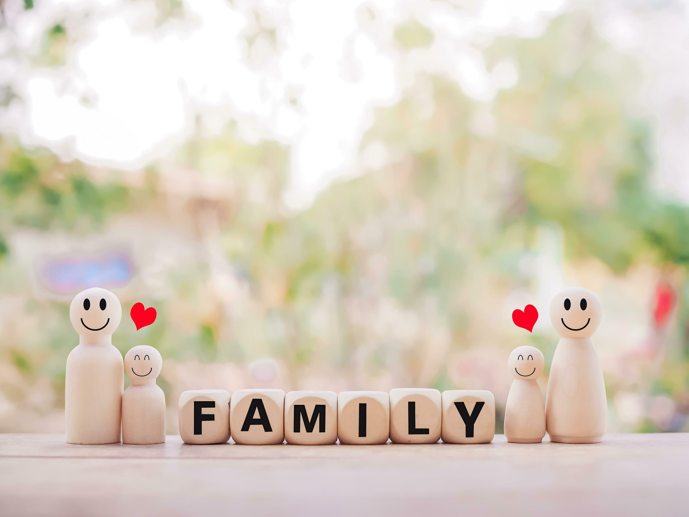 Wooden figure couple happy face and wooden block with word the FAMILY. The concept of romantic feelings, family relationship. Stock Free