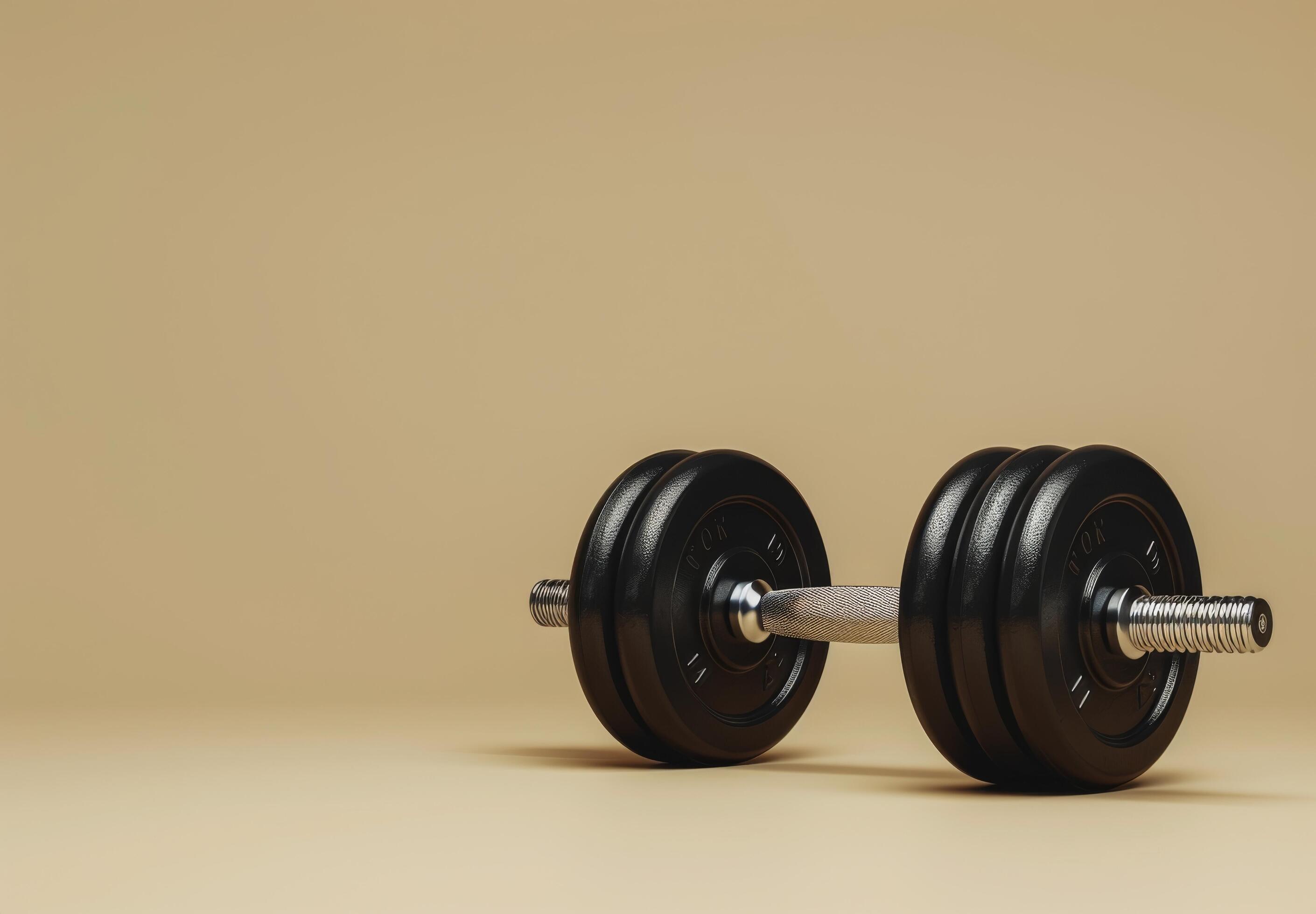 Single Black Dumbbell On A Beige Background Stock Free