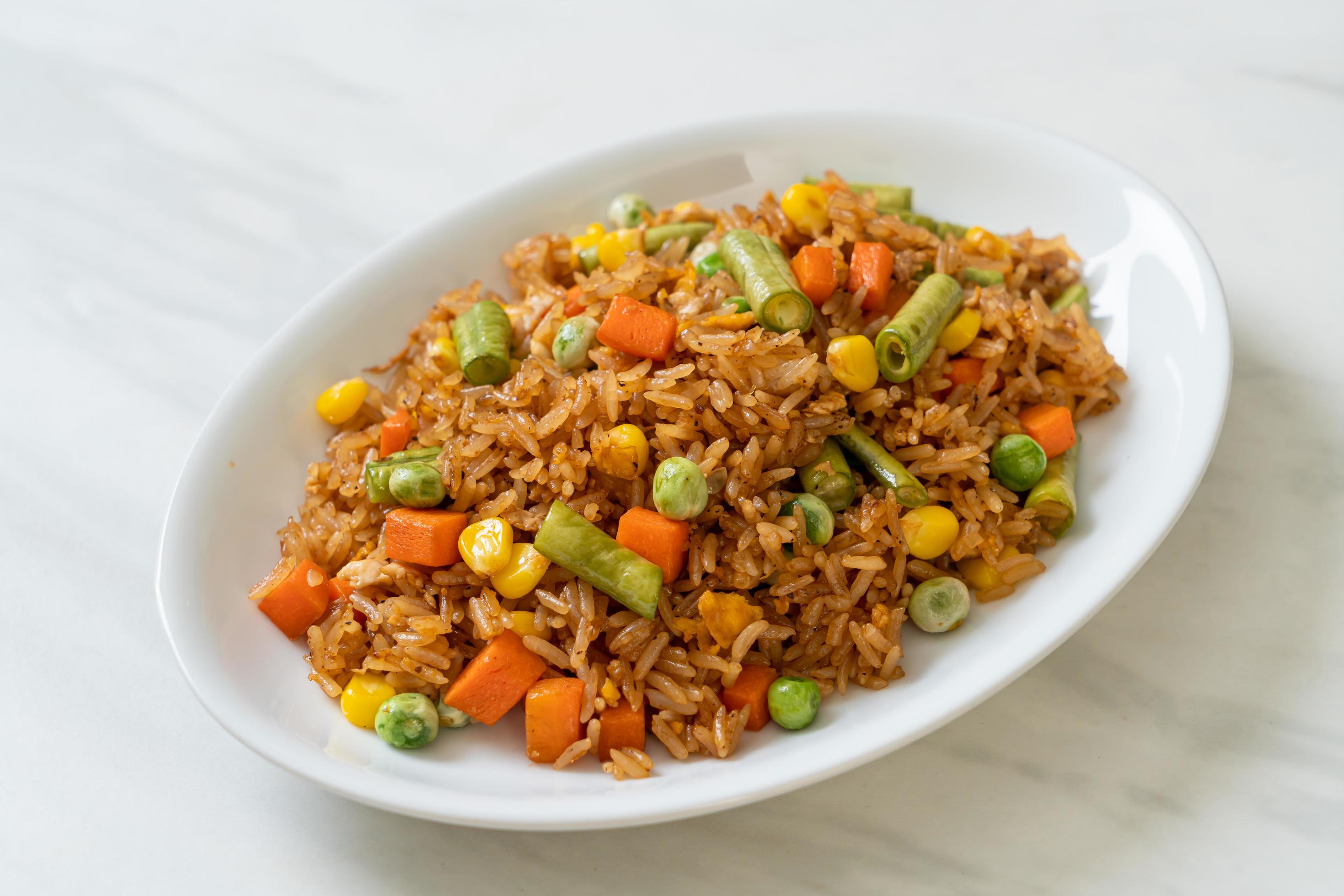 Fried rice with green peas, carrots, and corn – vegetarian and healthy food style Stock Free