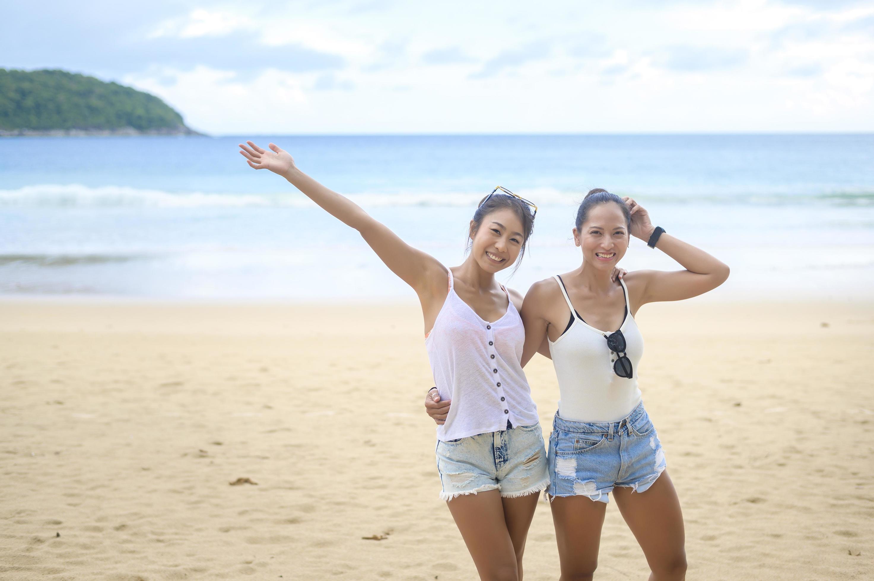 Two attractive women friends enjoying and relaxing on the beach, Summer, vacation, holidays, Lifestyles concept. Stock Free