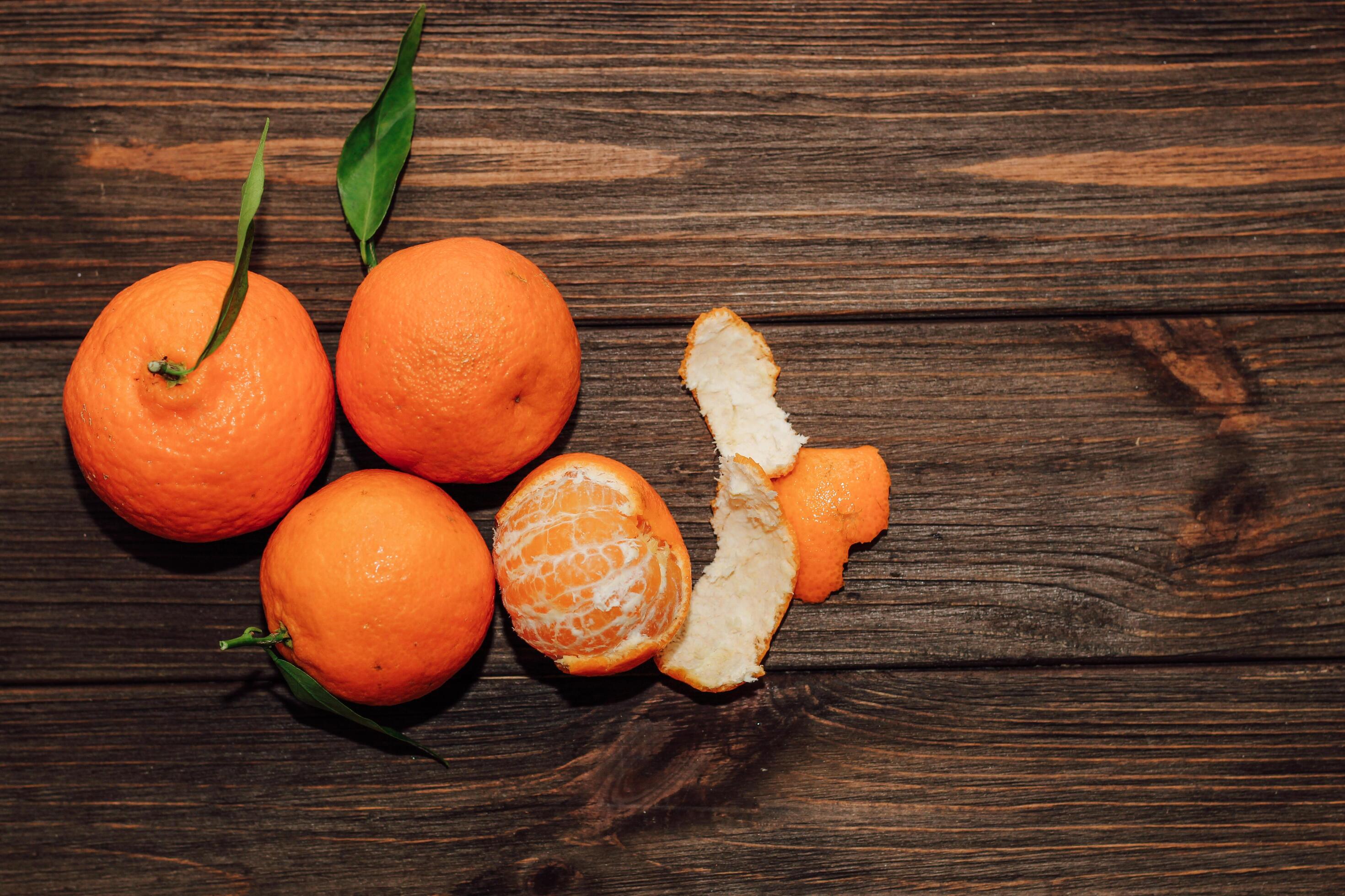 Tangerines on the background of a wooden brown table with boards Stock Free