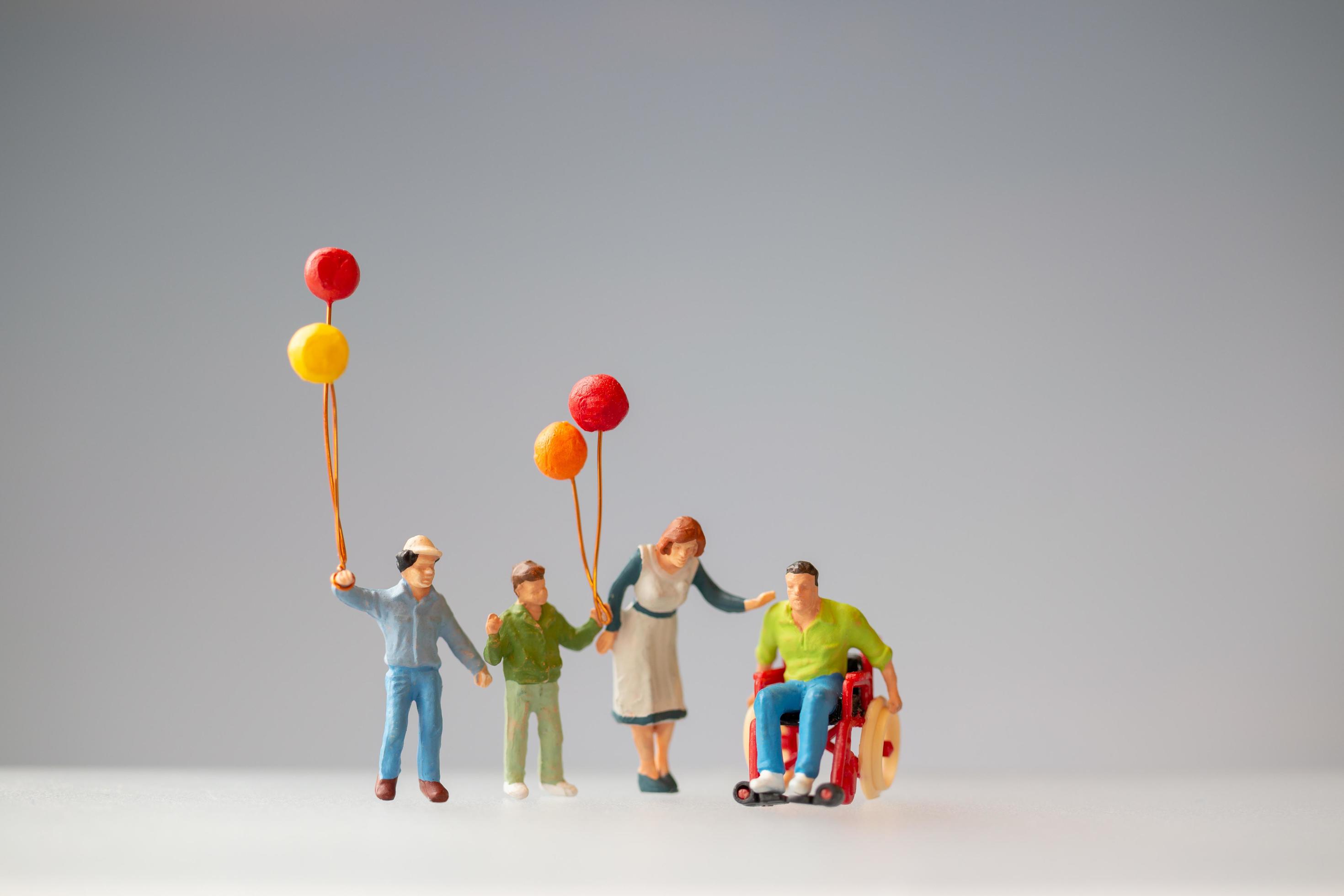 Miniature figurines of a family with balloons Stock Free