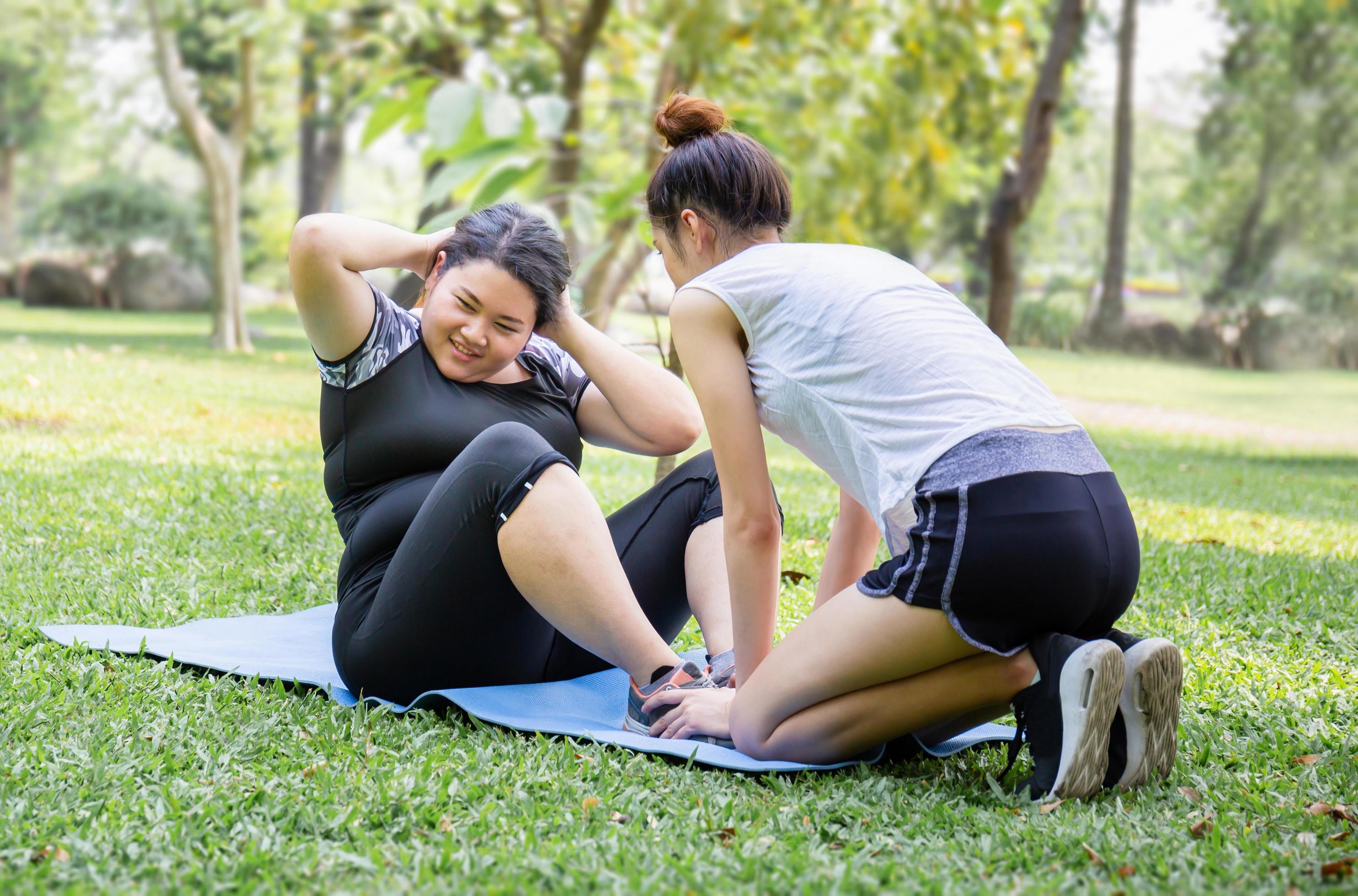 Young woman and friend exercising in the park, healthy and lifestyle concepts Stock Free