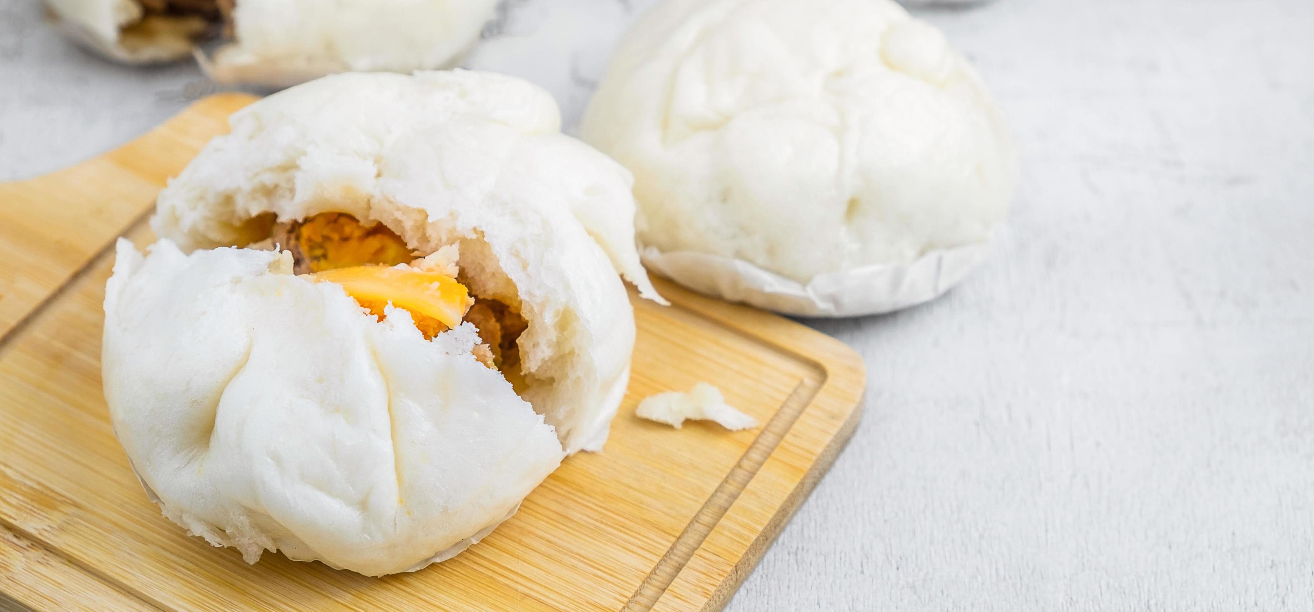 The Chinese food menu of Steamed Buns split in the middle reveals Pork Belly on white table Stock Free