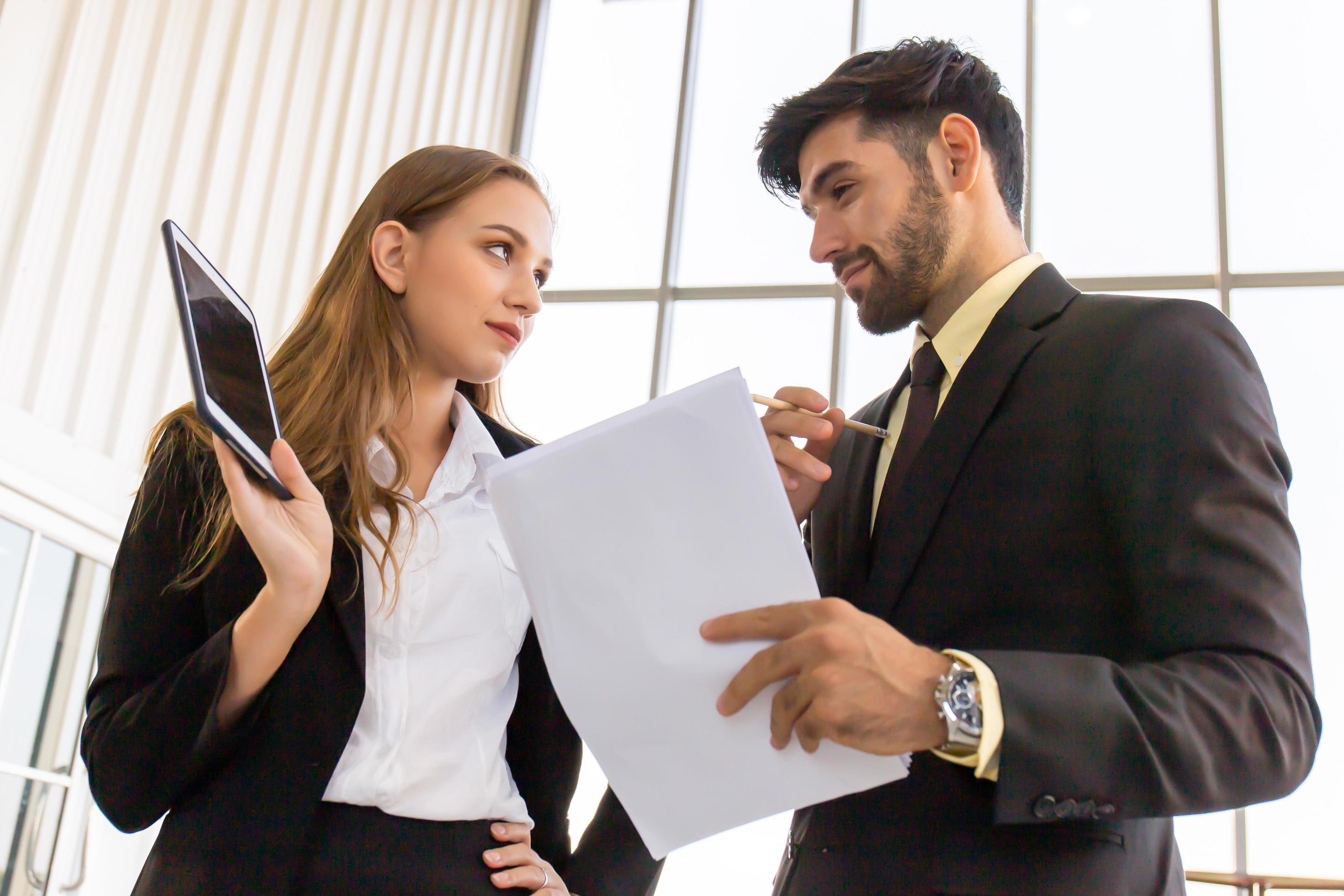 Two business men and women standing meeting in the office Stock Free