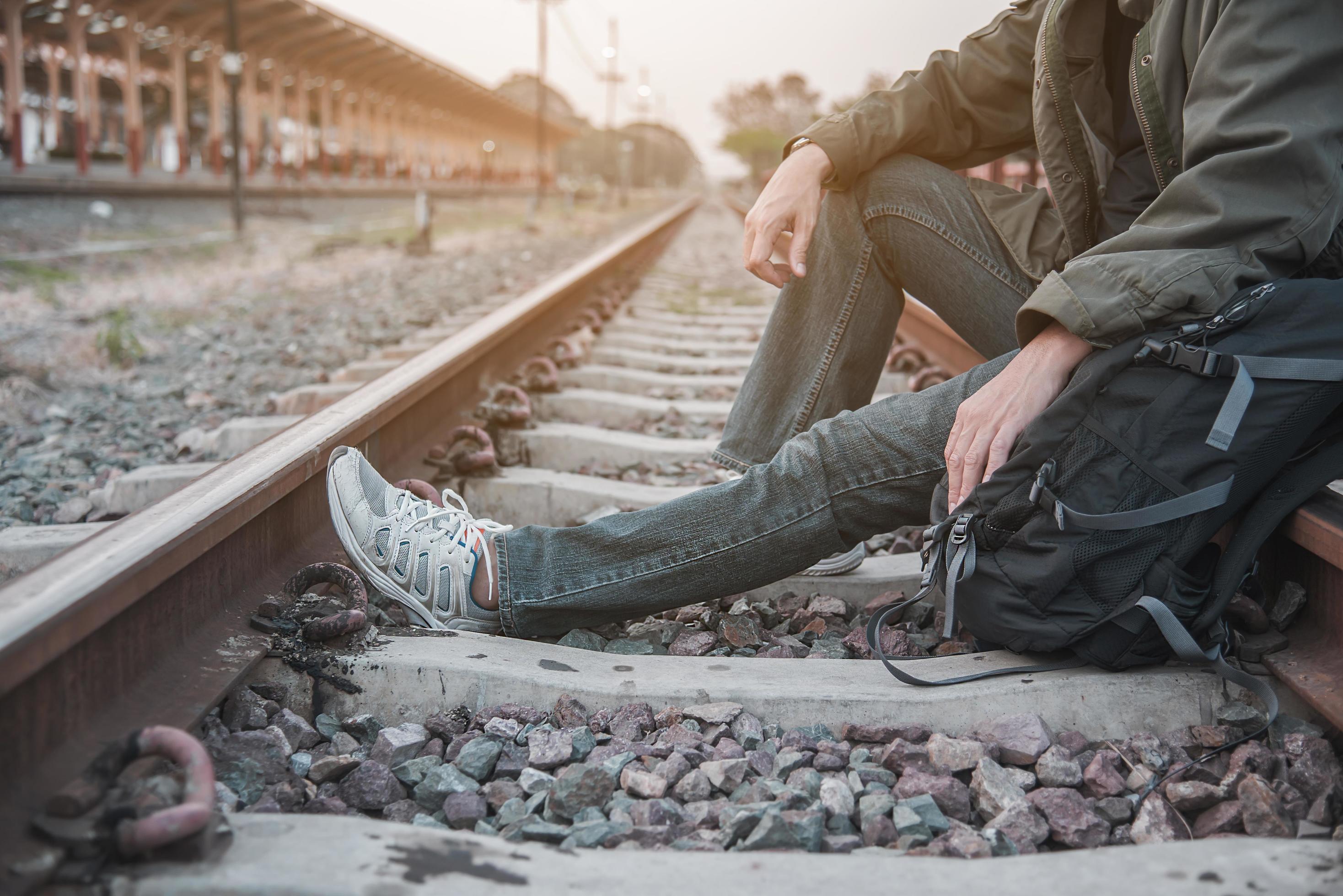 Travel man wait train at platform – people vacation lifestyle activities at train station transportation concept Stock Free