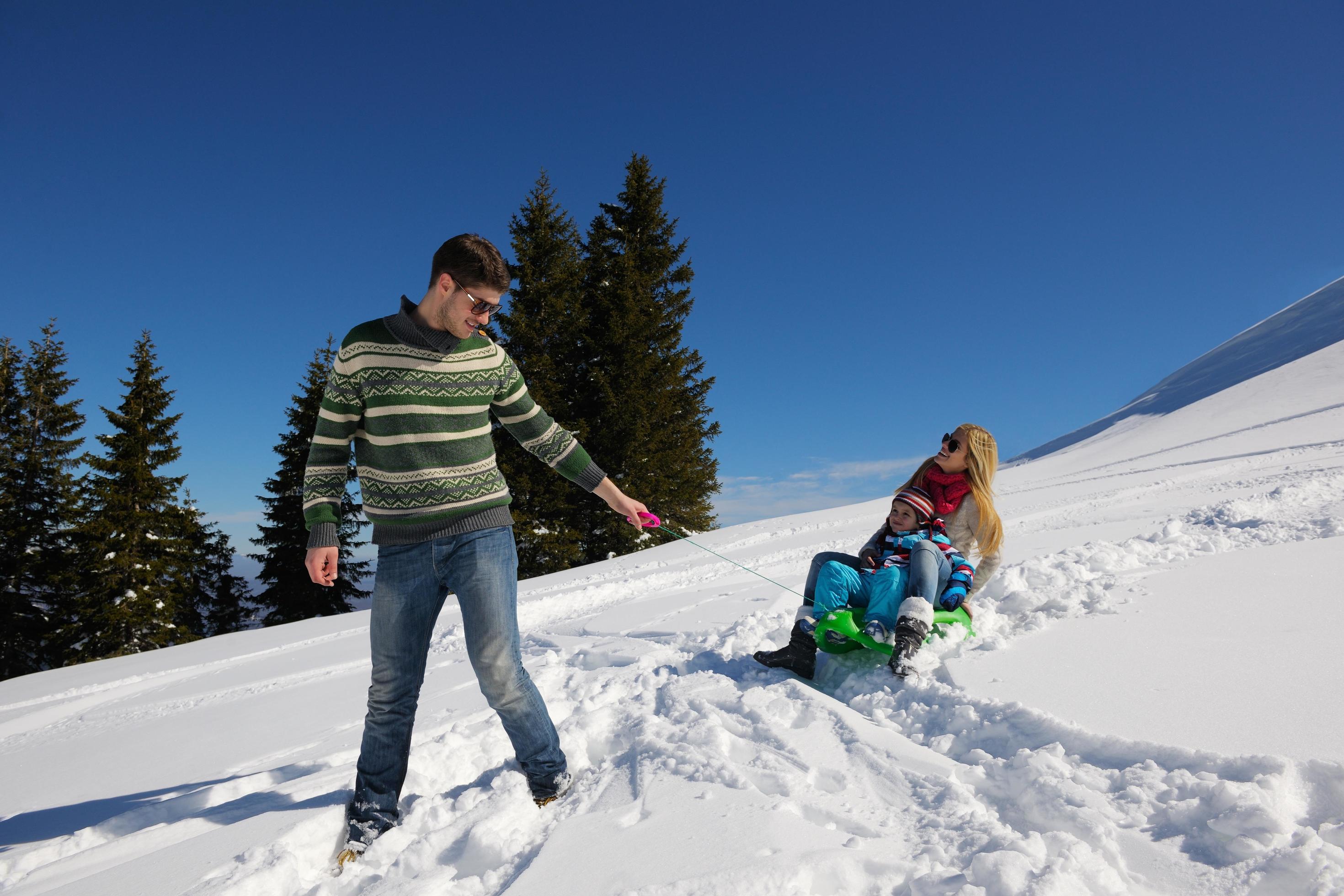 family having fun on fresh snow at winter vacation Stock Free