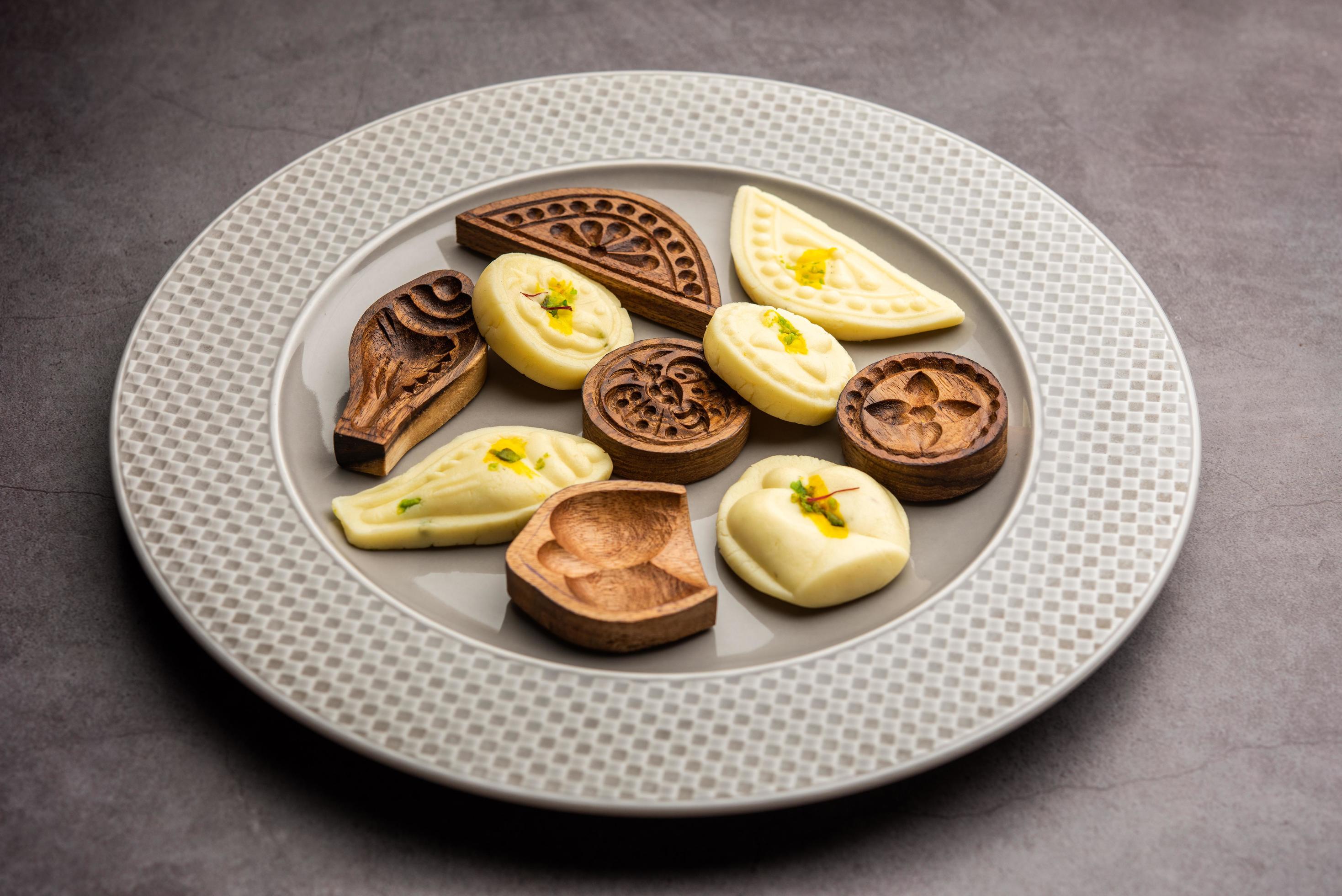 Sandesh or Shondesh sweet food with wooden moulds in a plate Stock Free